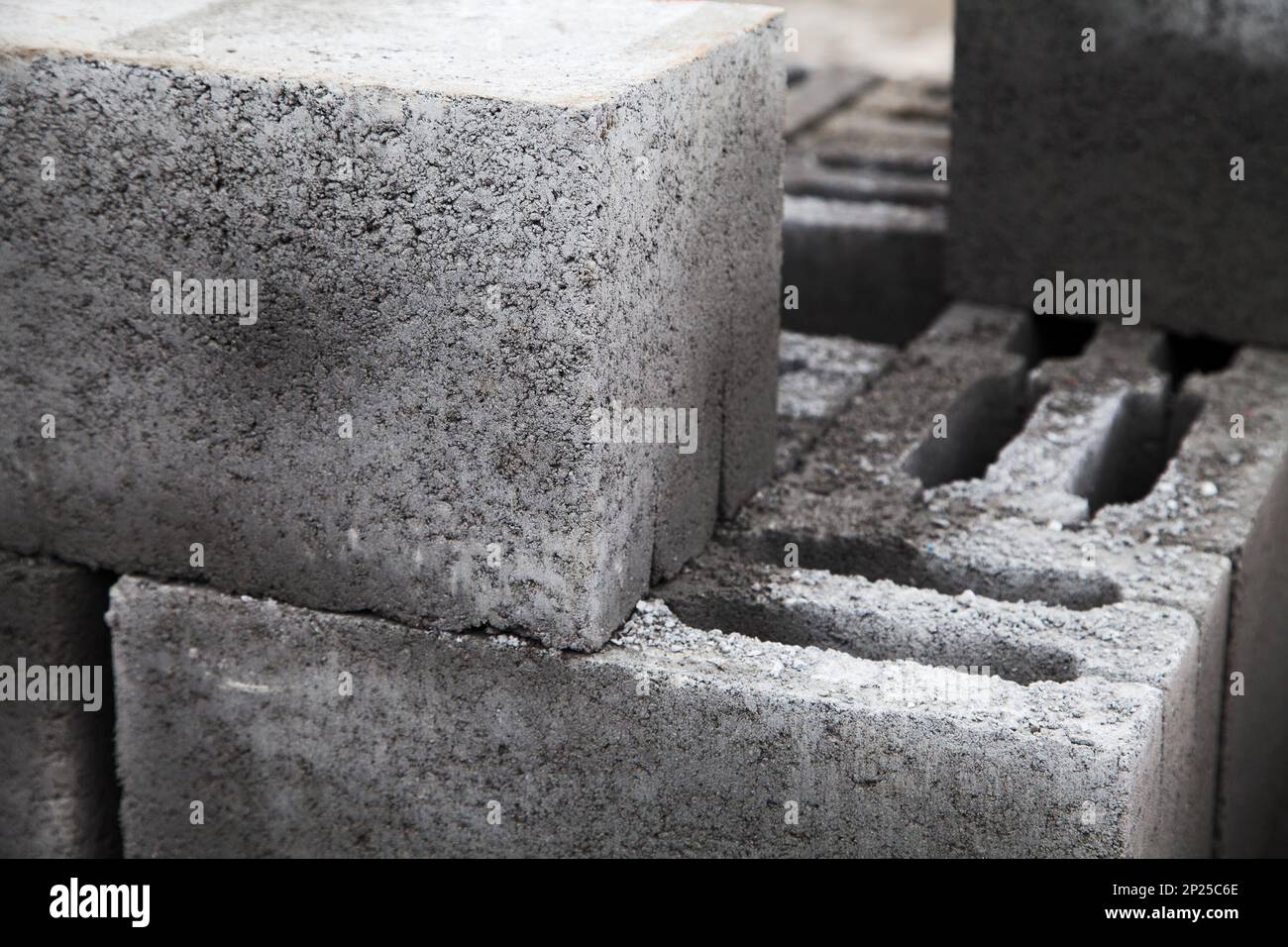 Gray building cinder blocks made of cement stacked close-up. A lot of large concrete bricks stacking texture. Shallow focus Stock Photo