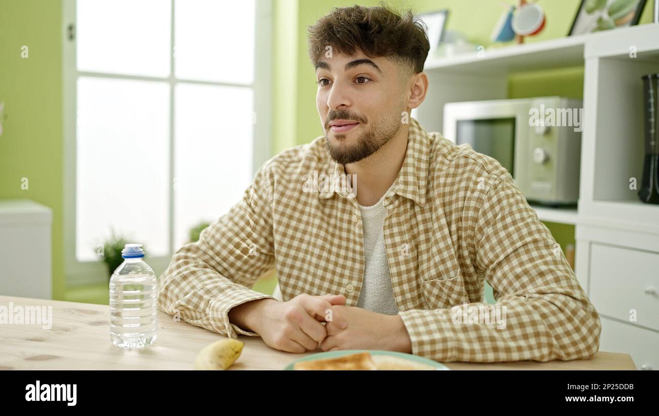 Young arab man having breakfast speaking at home Stock Photo