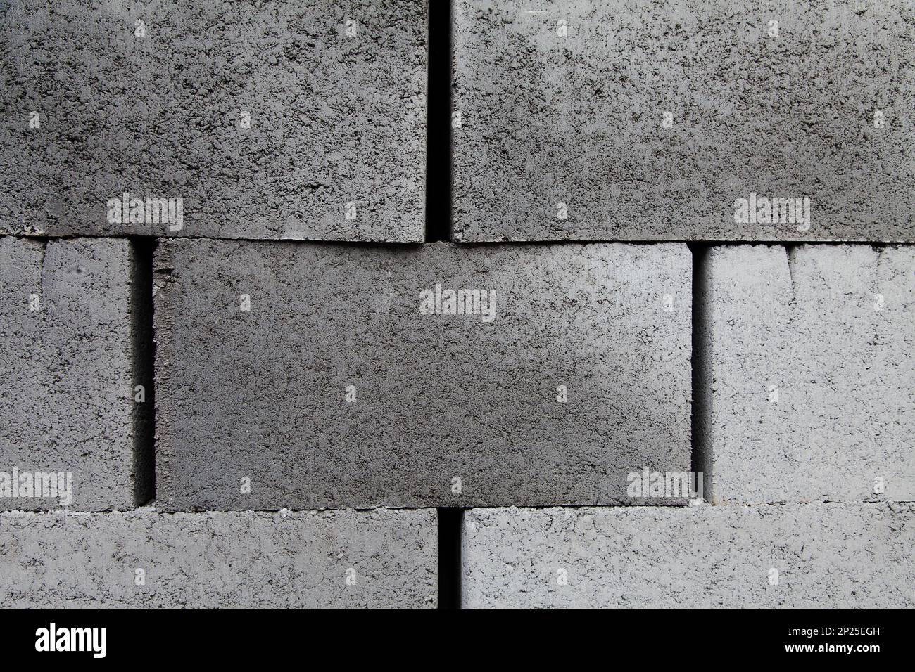 Gray building cinder blocks made of cement stacked close-up background. Lot of large concrete bricks stacking texture Stock Photo