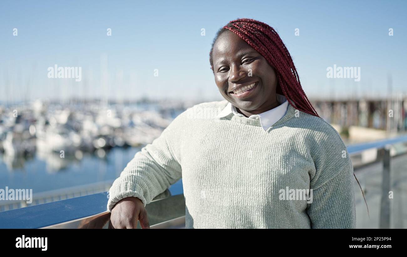 African woman with braided hair smiling confident at seaside Stock ...