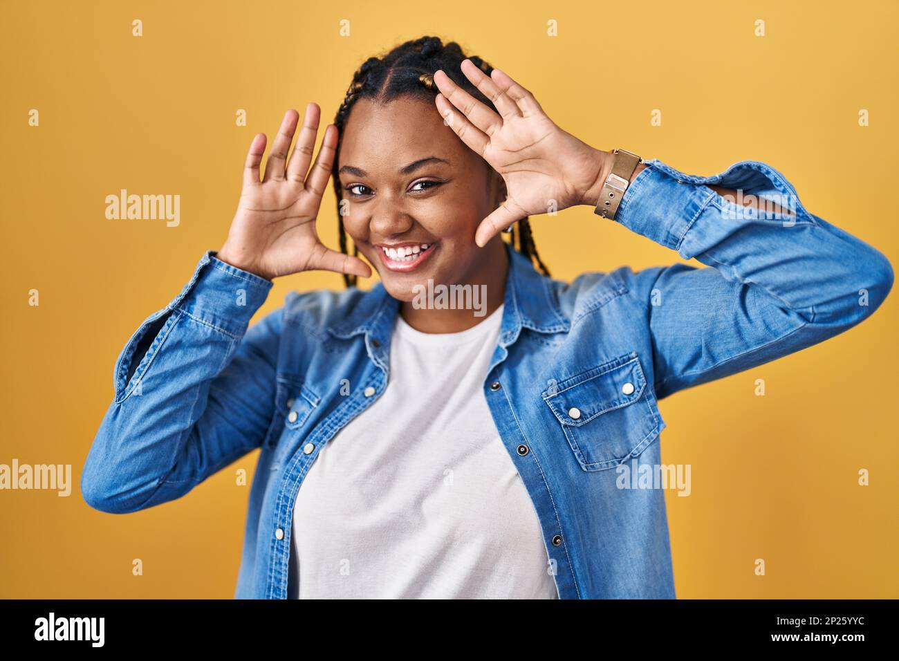 African american woman with braids standing over yellow background ...