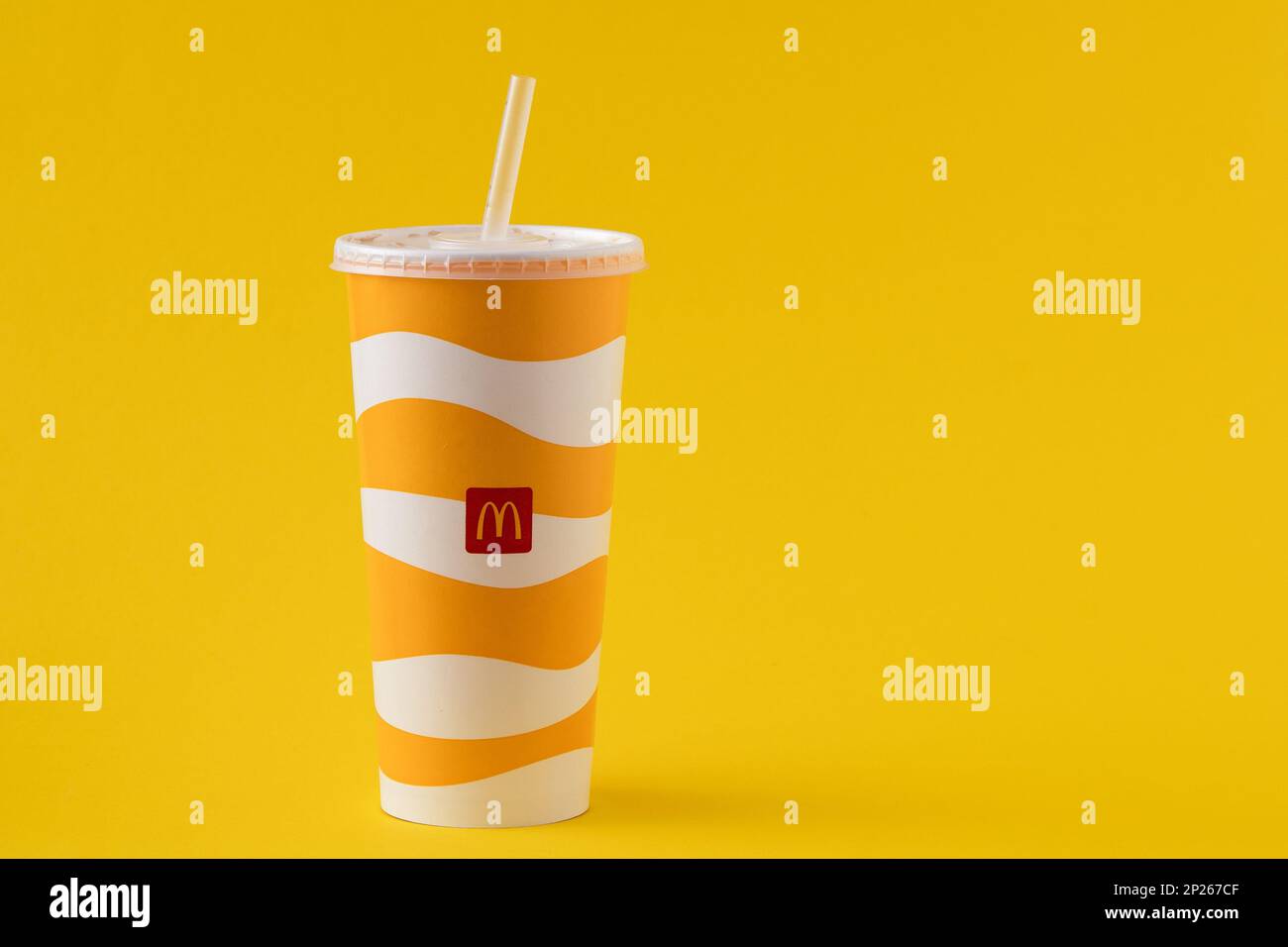 Yellow glass of McDonald's. Paper cup with lid. Takeaway drink ...