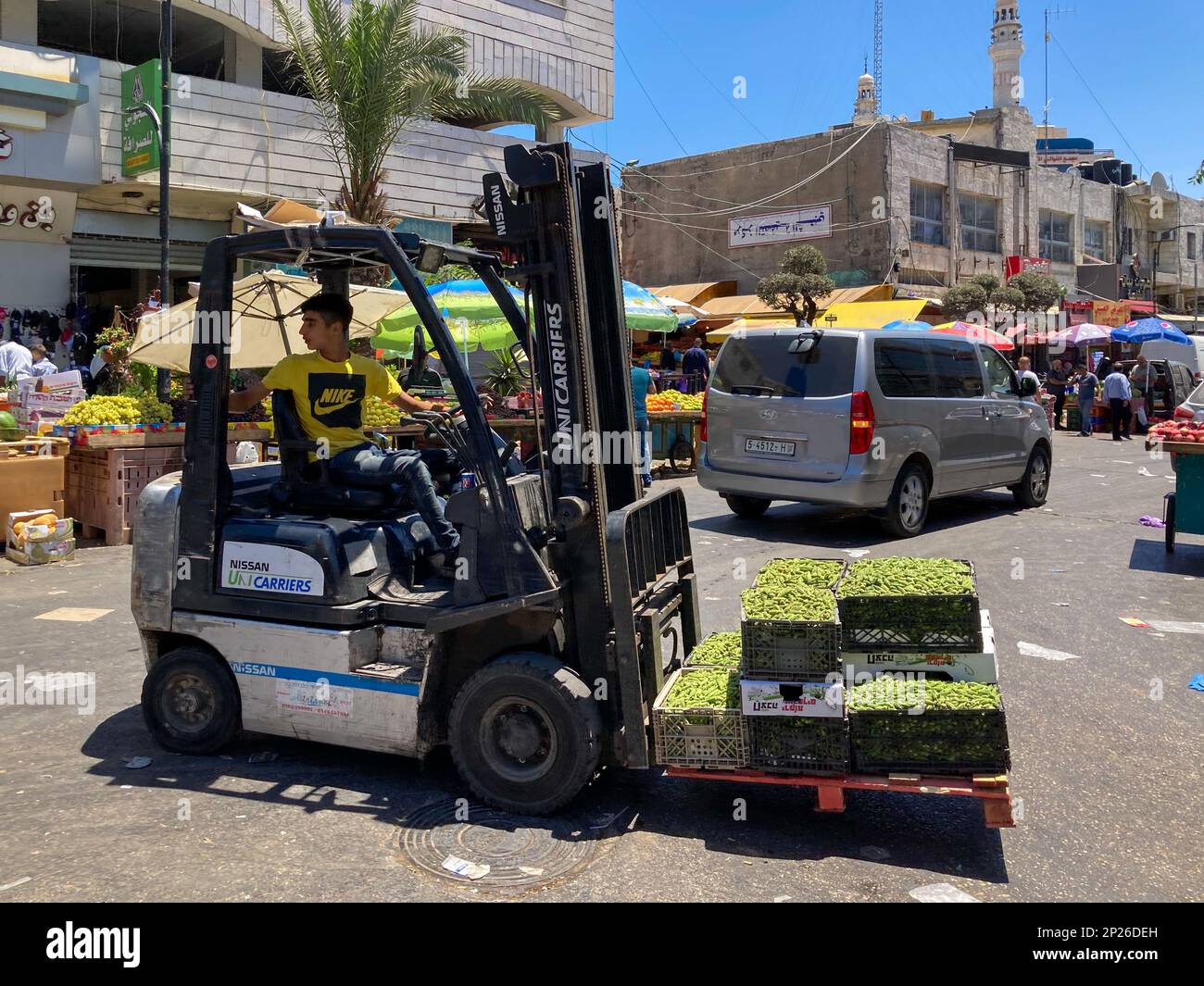 Ramallah, Ramallah and al-Bireh Governorate, Palestine, 8 July 2022: Young Arab Man with Yellow Shirt Transports Boxes of Green Peas on a Forklift in Stock Photo