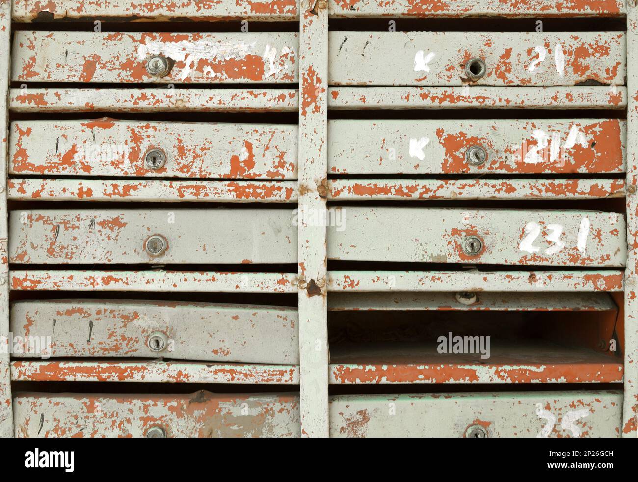 Block of very old damaged mailboxes in an apartment building. Many vintage painted postboxes in a row vintage background Stock Photo