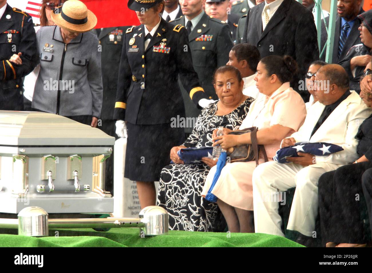 Iris Santiago holds the American flag that was draped over the casket ...
