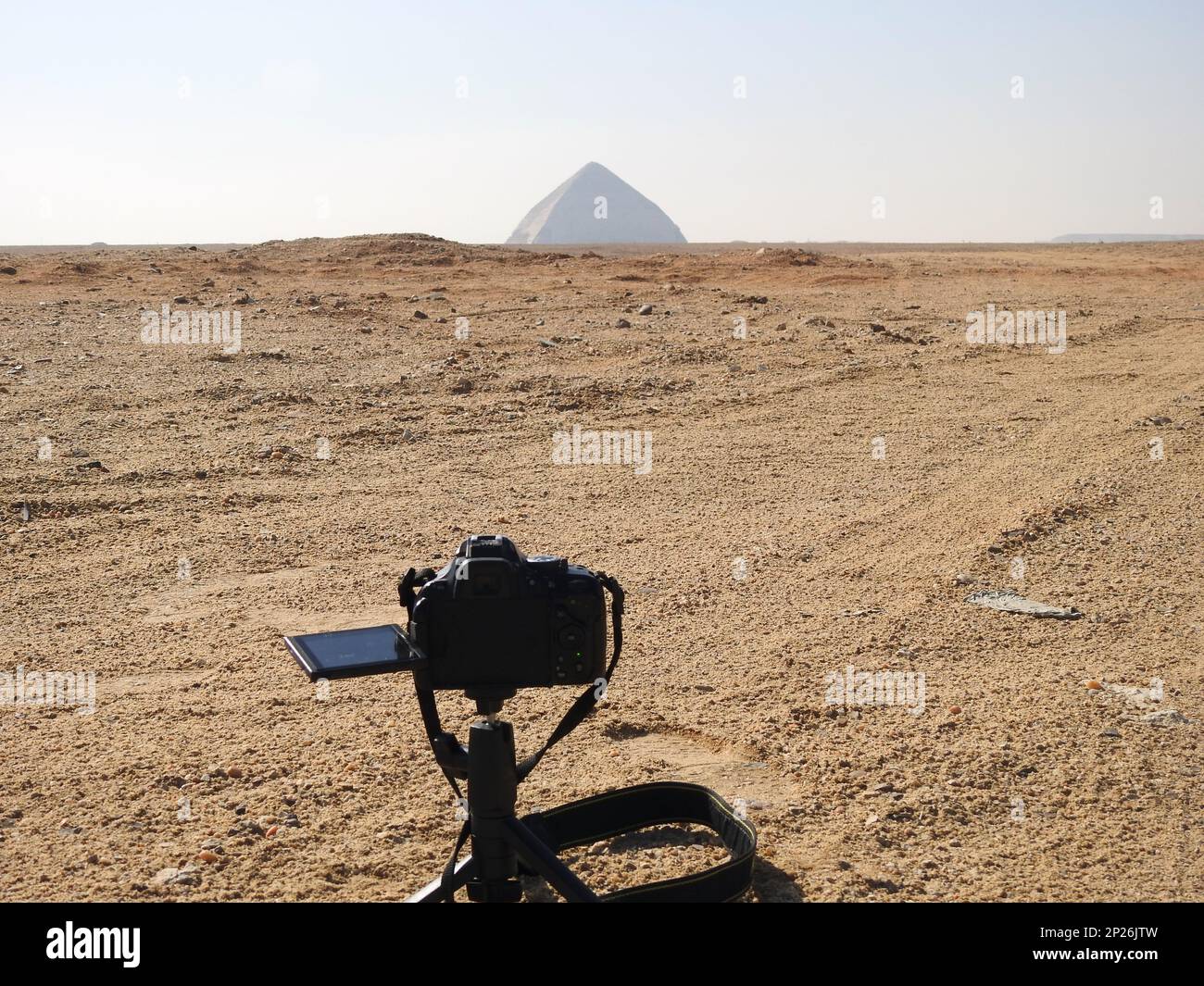 A digital DSLR camera on a tripod Photographing the Bent Pyramid of