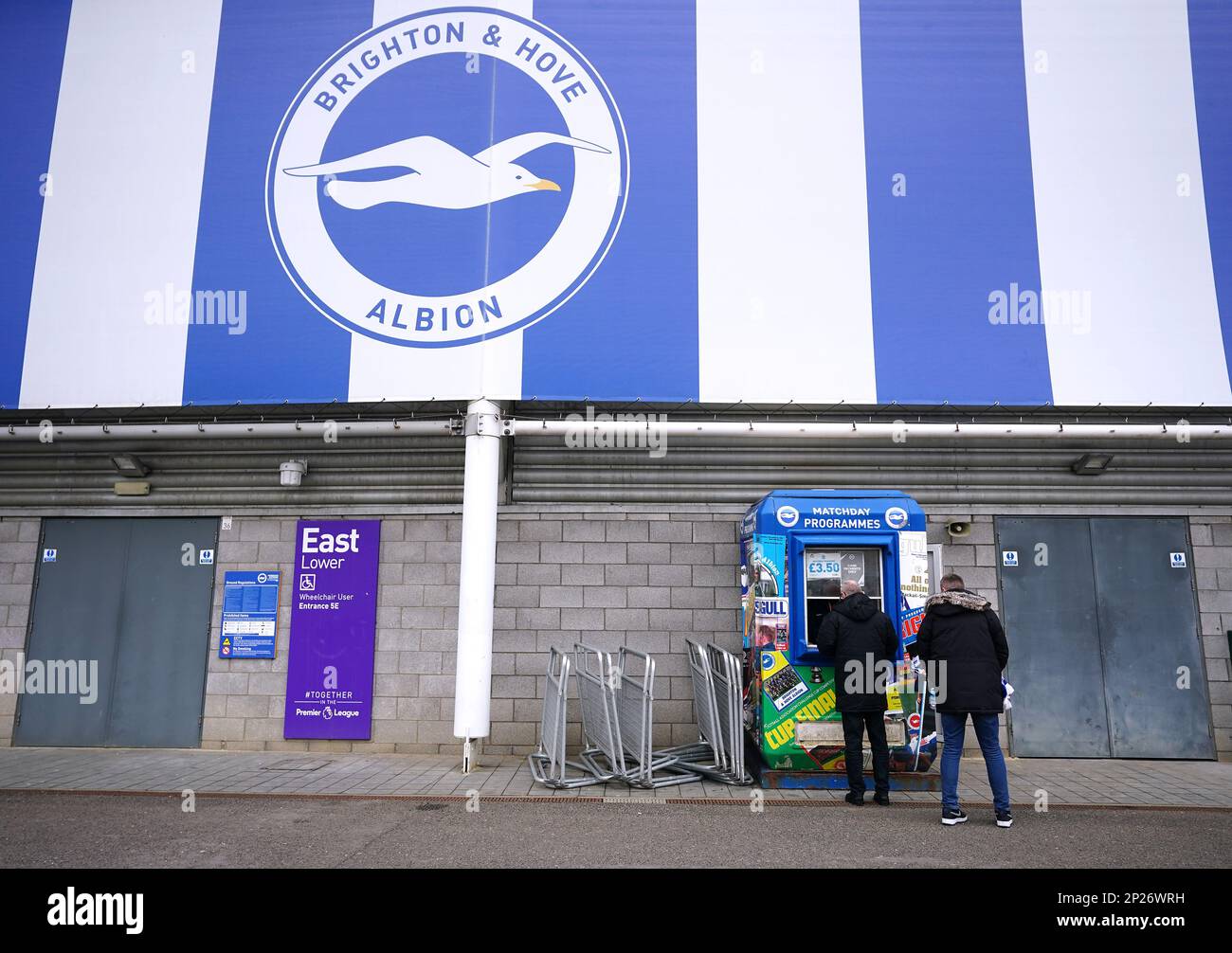 Fans buy match day programmes outside the ground ahead of the Premier ...