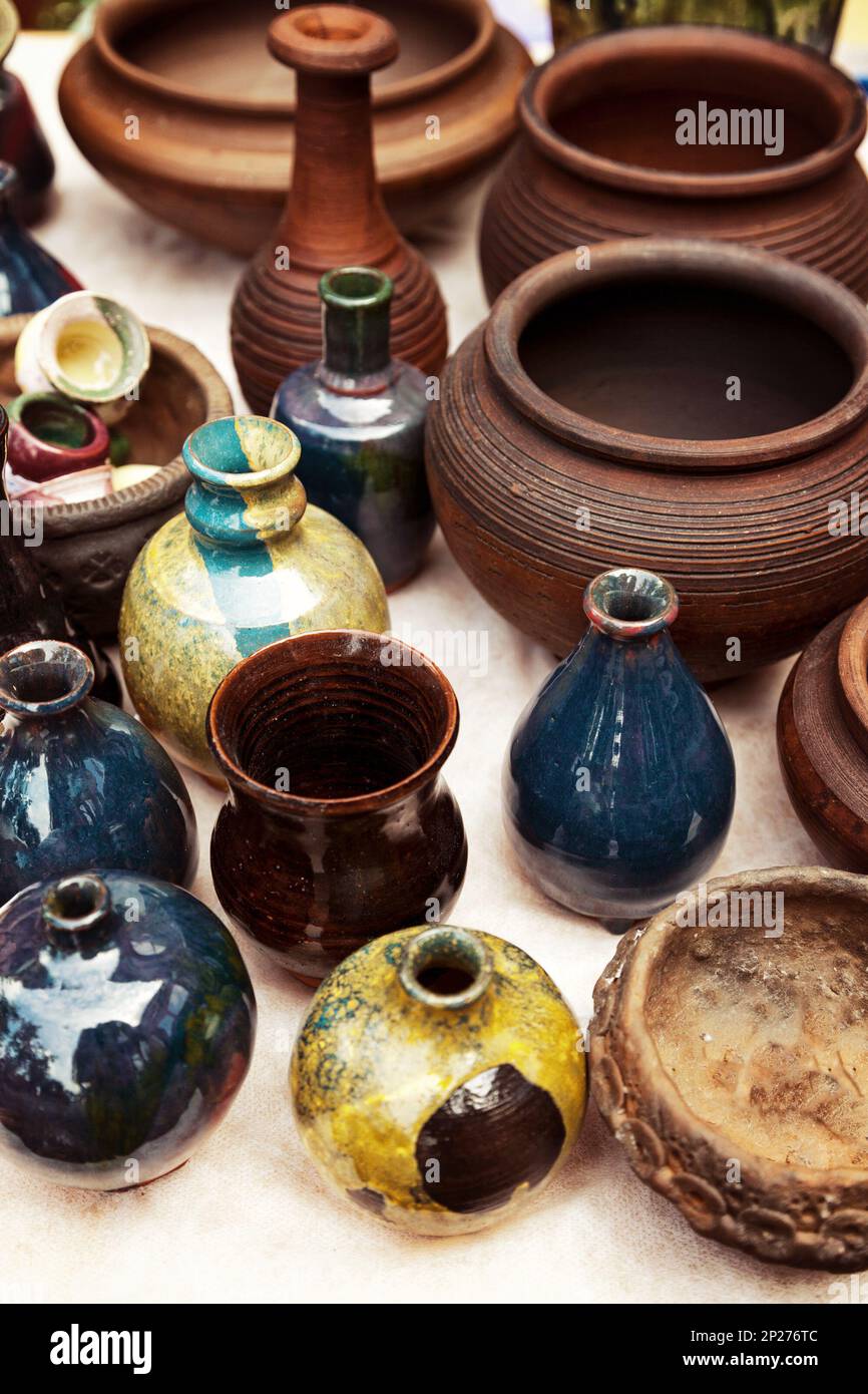 Lots of handmade earthenware - ceramic pots and vases at pottery shop. Colorful clayware background Stock Photo