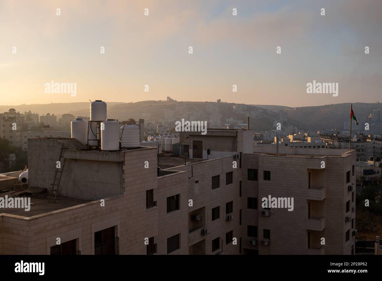 Ramallah Ramallah And Al Bireh Governorate Palestine 12 July 2022 Ramallah Cityscape At Dawn With High Buildings And Mountains Facing The Sun 2P28P62 