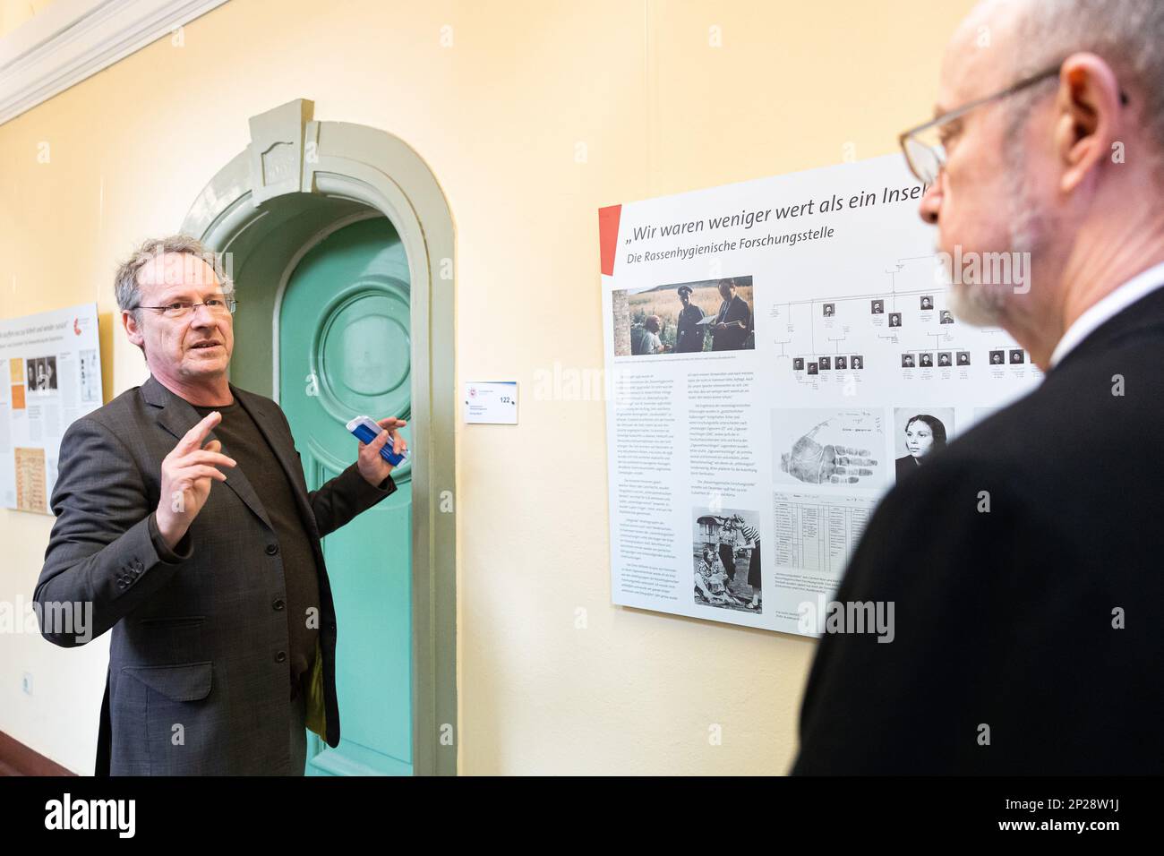 04 March 2023, Lower Saxony, Hanover: Historian Boris Erchenbrecher (l), Lower Saxony Counseling Center for Sinti and Roma e.V., stands with Volker Kluwe (r), Chief of Police of the Hanover Police Department, in front of an information panel at the Hanover Police Department during a guided tour of the exhibition. The special exhibition 'From Lower Saxony to Auschwitz' deals with the persecution of Sinti and Roma during the National Socialist era. As part of the examination of the role of the police during the Nazi era, it takes place on the grounds of the Hanover Police Directorate. The backgr Stock Photo