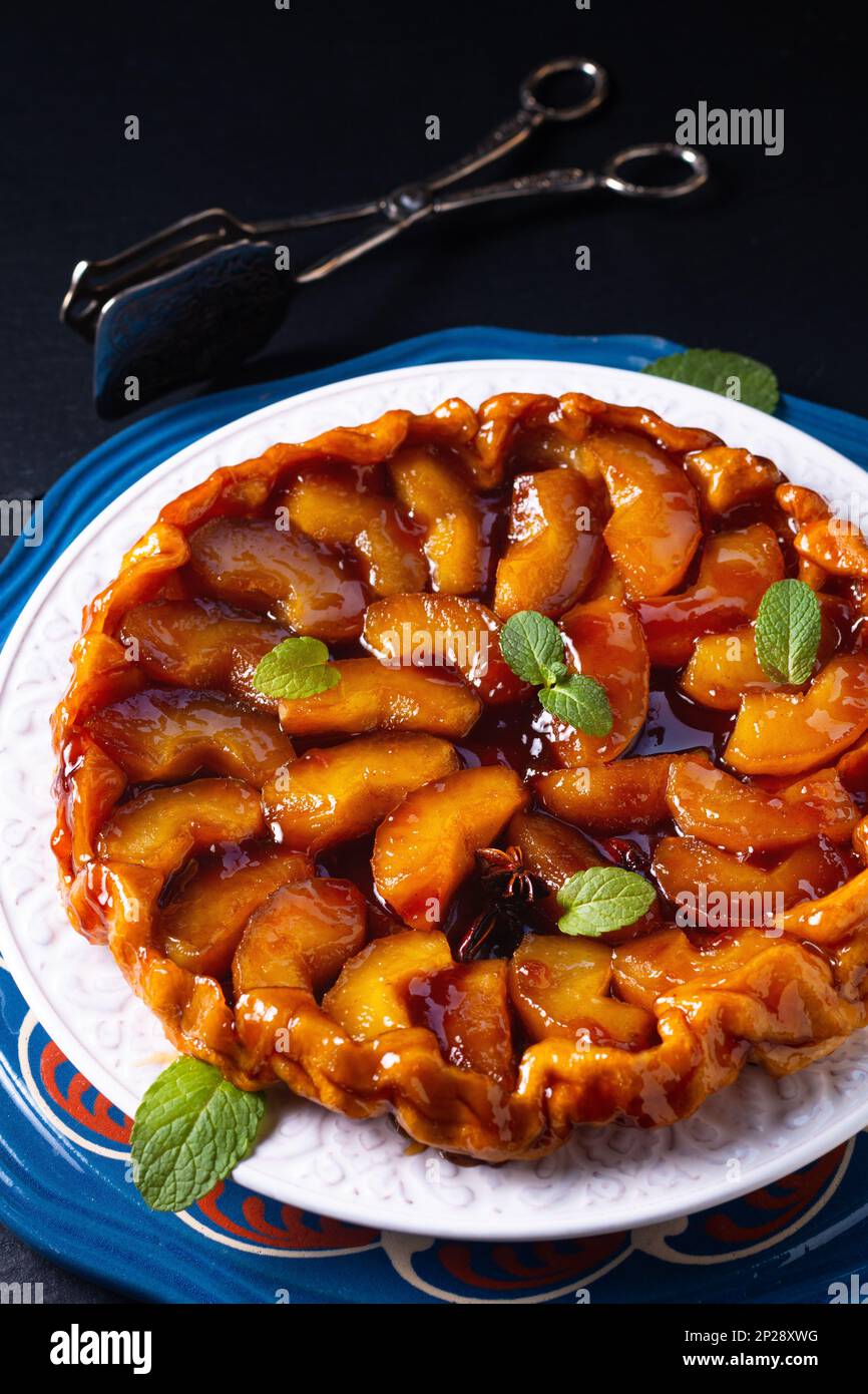 Food concept homemade tarte tatin upside down apple tart pie on black