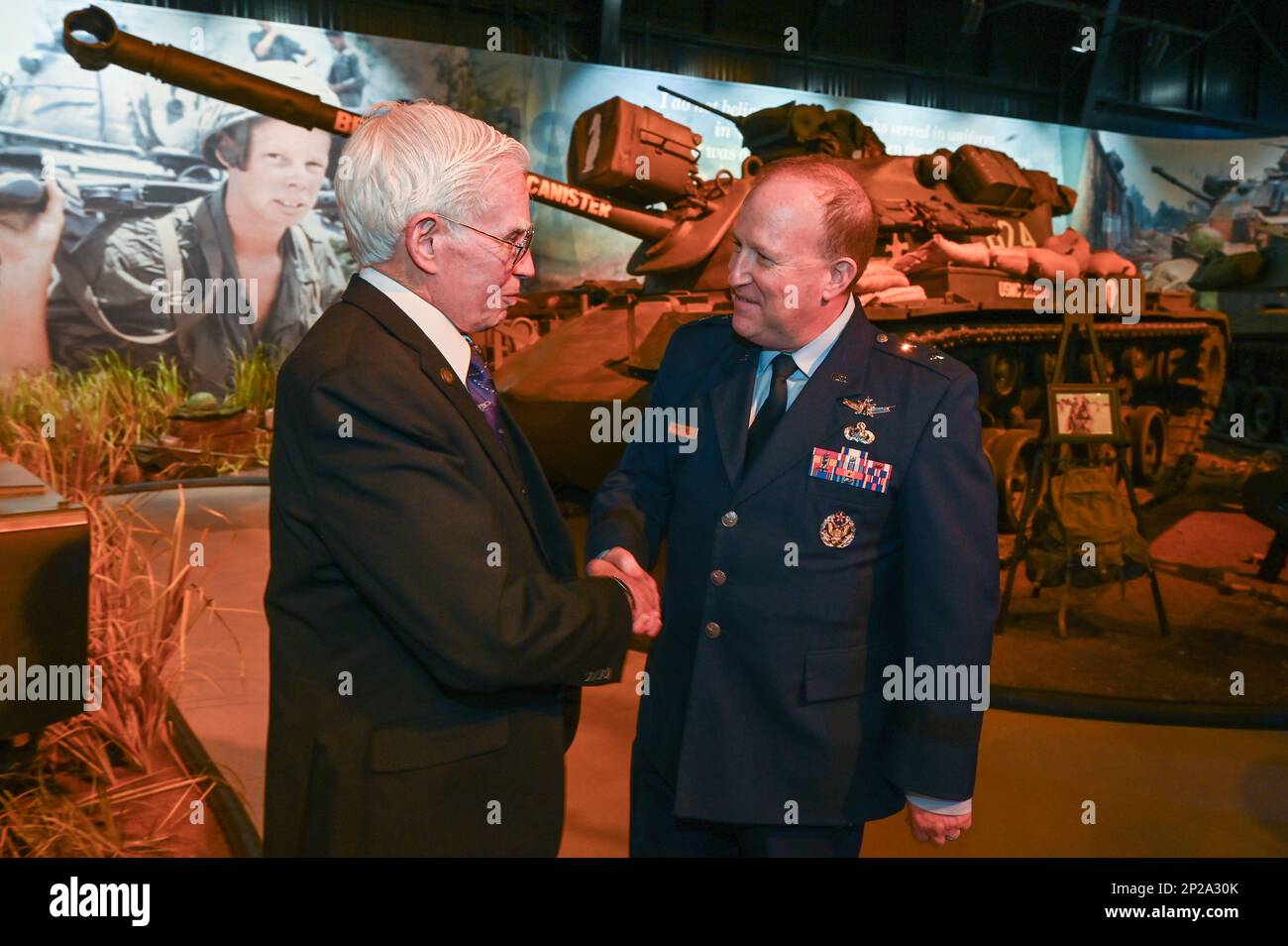 Maj. Gen. Anthony Genatempo, right, program executive officer, Command, Control, Communications, Intelligence and Networks, introduces himself to retired U.S. Air Force Col. Michael Brazelton during the grand opening of the Hanoi Hilton Vietnam Exhibit at The American Heritage Museum, Hudson, Mass., Feb 11. The exhibit featured two original cells from Hỏa Lò prison, also known as the 'Hanoi Hilton,” in North Vietnam. Brazelton’s aircraft was shot down on Aug. 7, 1966 on his 120th combat mission over Thai Nguyen. He spent more than six years as a prisoner of war. Stock Photo