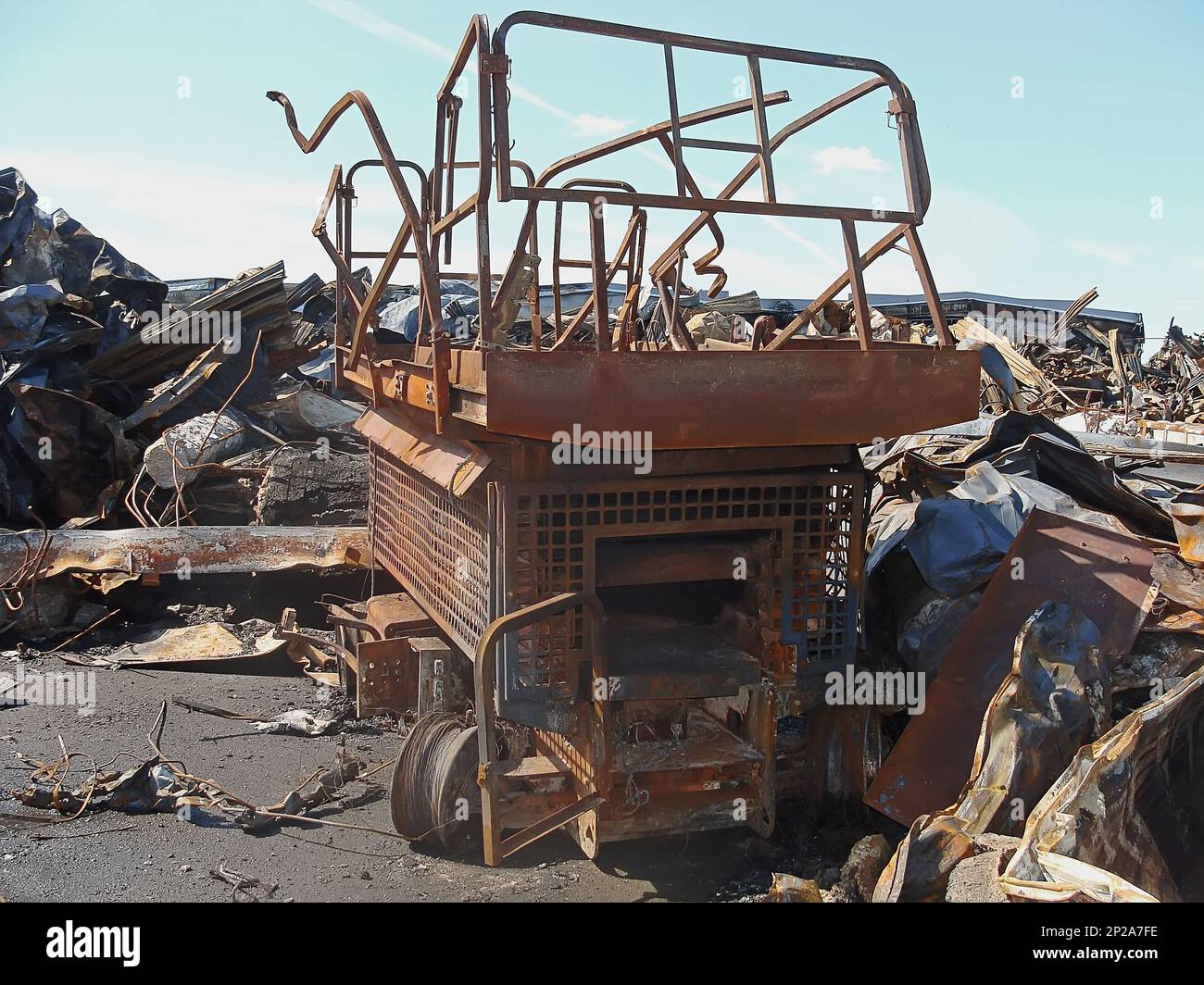 A burnt construction mobile lift among a pile of building debris and ...