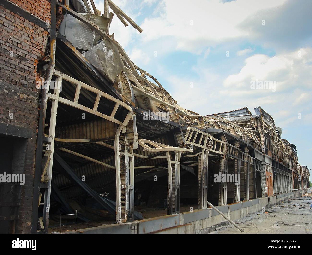 A warehouse with a loading ramp after a fire. Burnt metal frame of the building. Consequences of the fire. Stock Photo