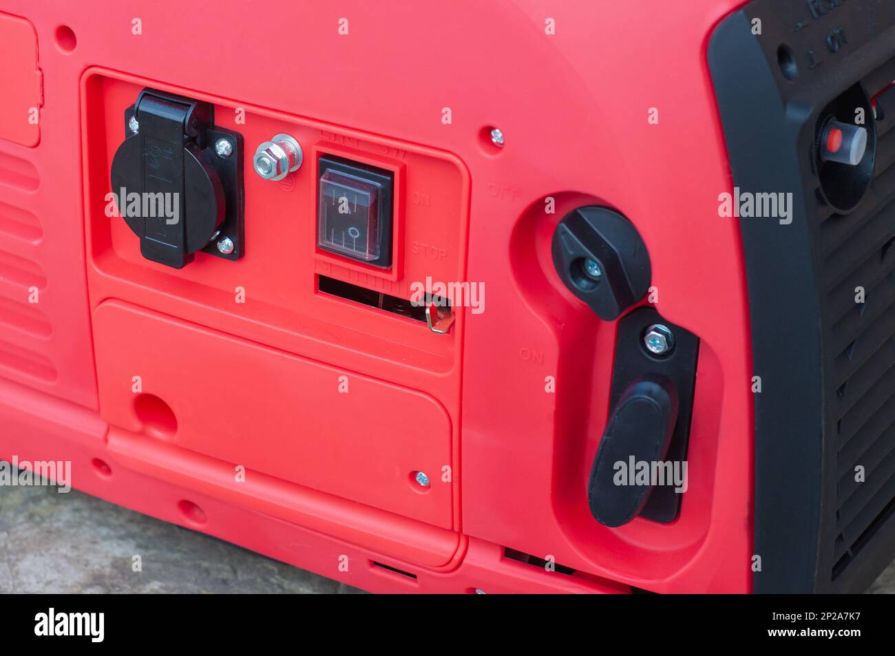 The red body of the electric gasoline generator from honda. Compact mobile voltage generator. Stock Photo