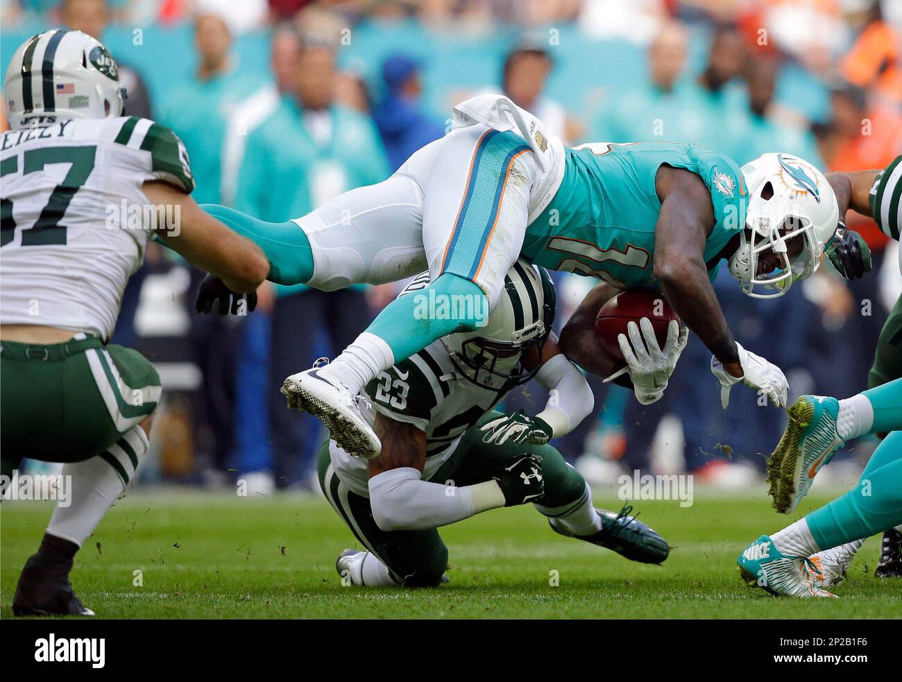 Miami Dolphins' Jarvis Landry, top right, is sent sprawling by a