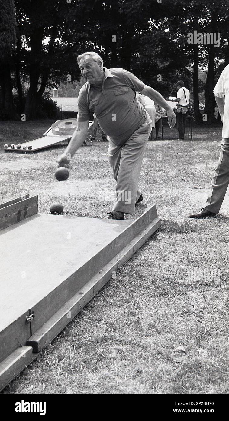 1989, historical, country fair, bowls, an elderly gentleman bowling a ball along a wooden ramp, England, UK. Stock Photo