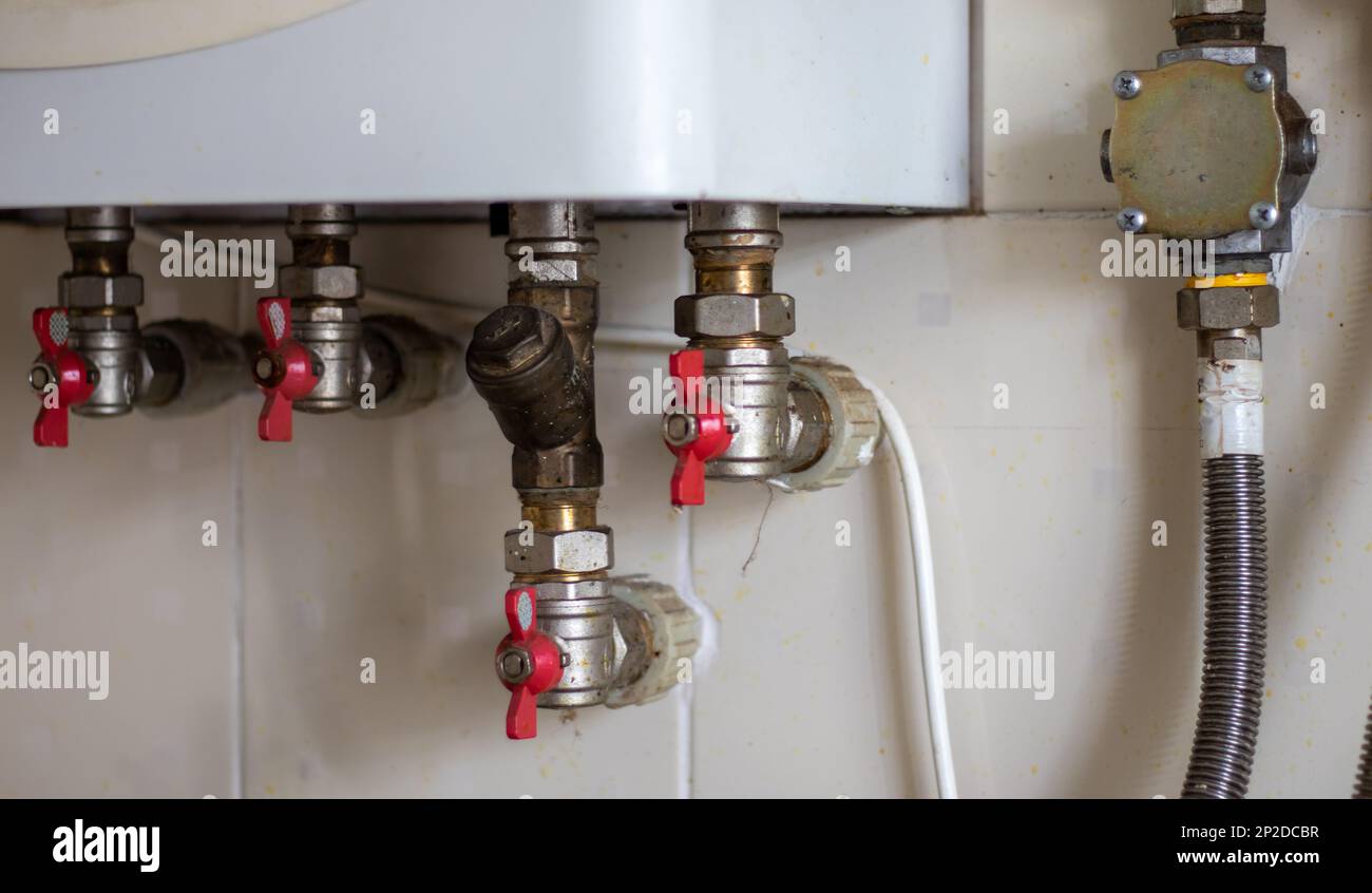Hidden water taps for connecting a gas boiler on a tiled wall. Plumbing connections for a