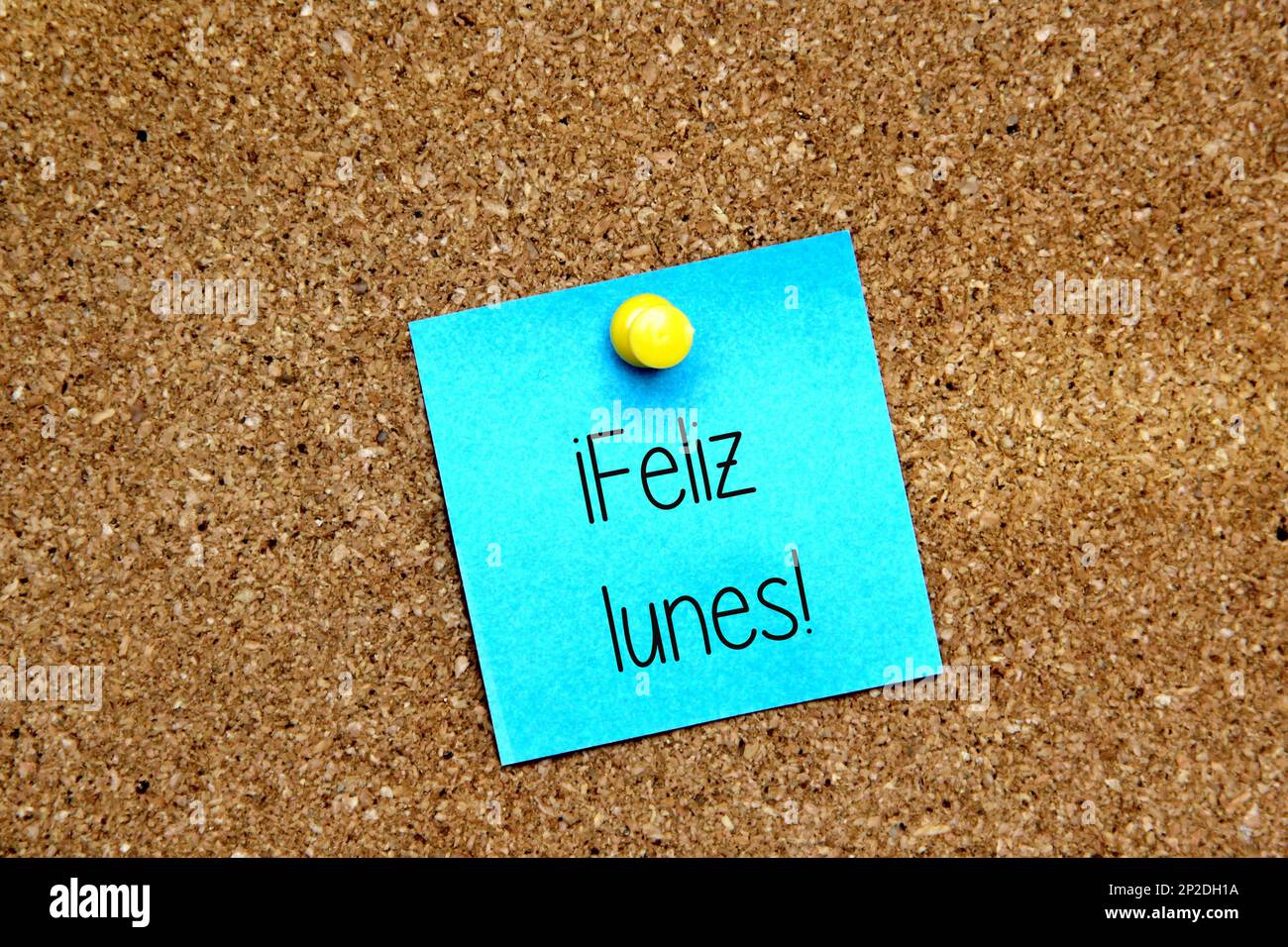 White and colored notes on cork board with message in spanish "Happy