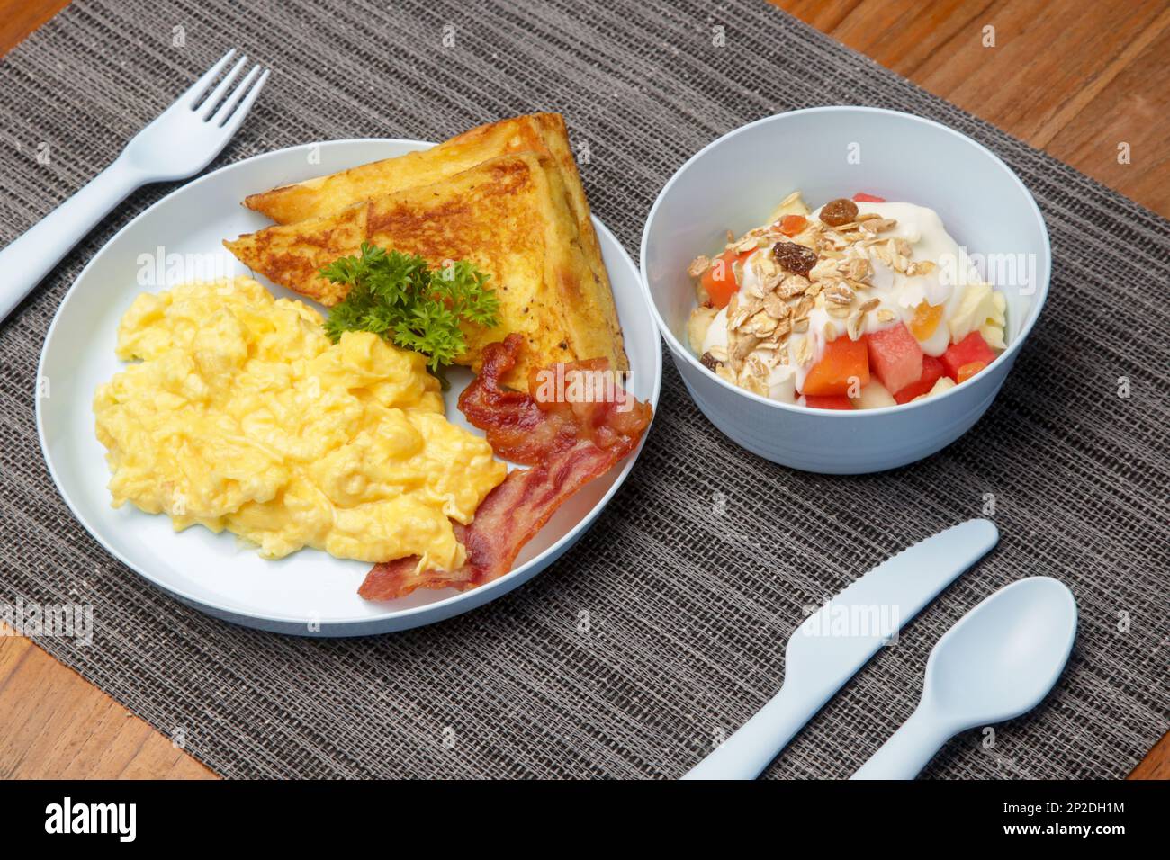 Kids menu, scrambled eggs, bacon, toast and muesli with yoghurt served