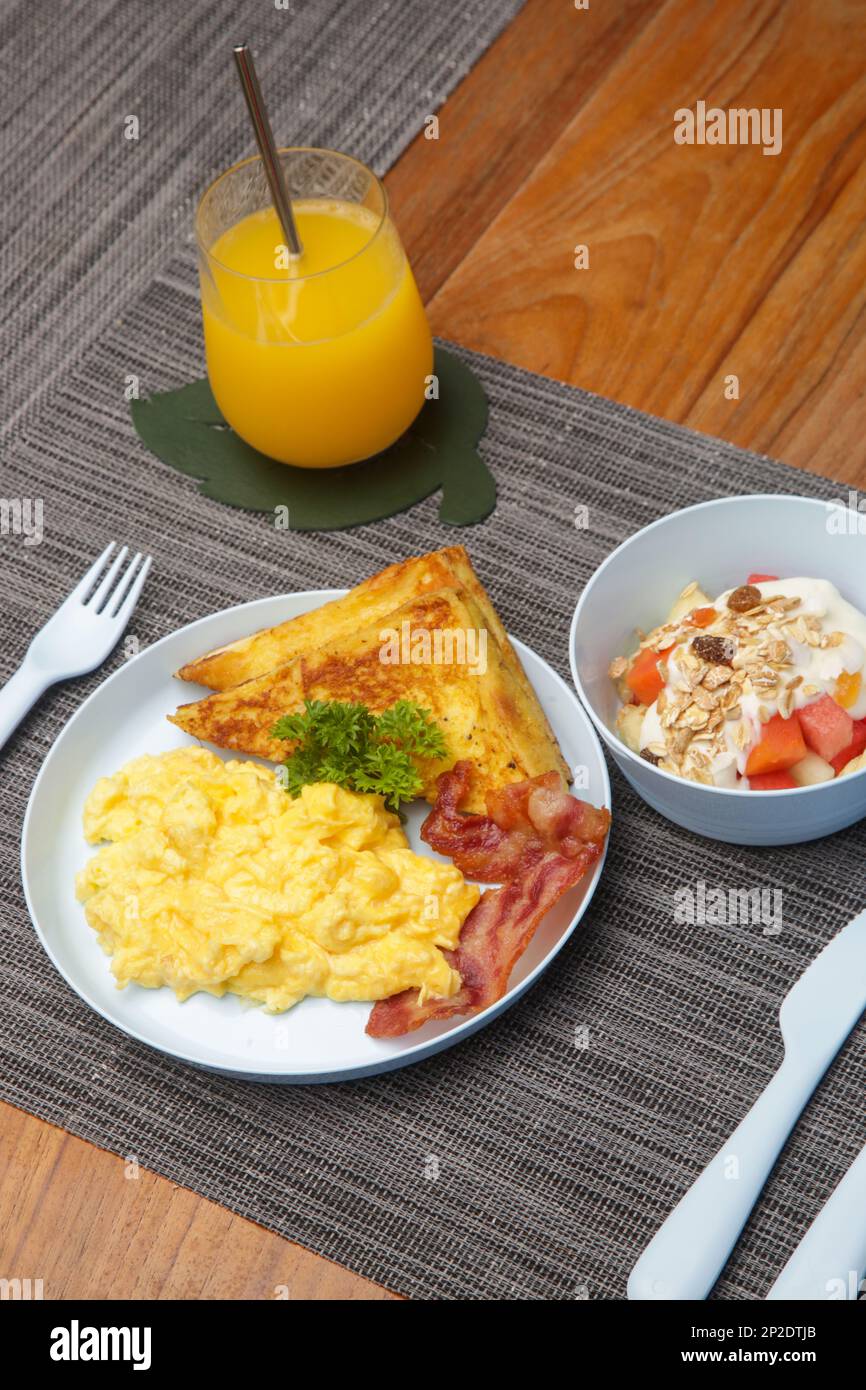Kids menu, scrambled eggs, bacon, toast and muesli with yoghurt served