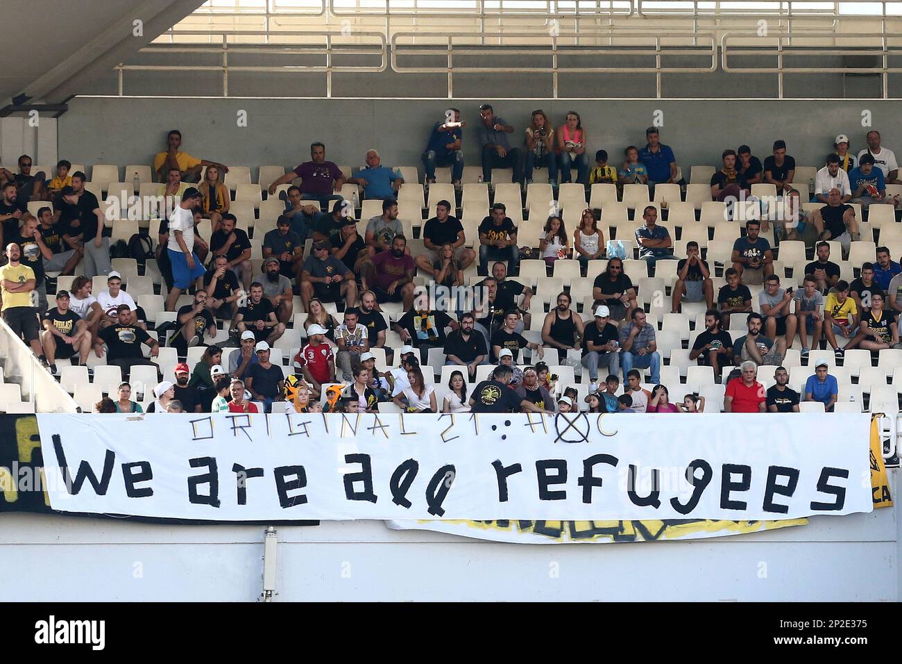 syrian-refugees-invited-by-aek-athens-fans-sit-behind-a-banner-while