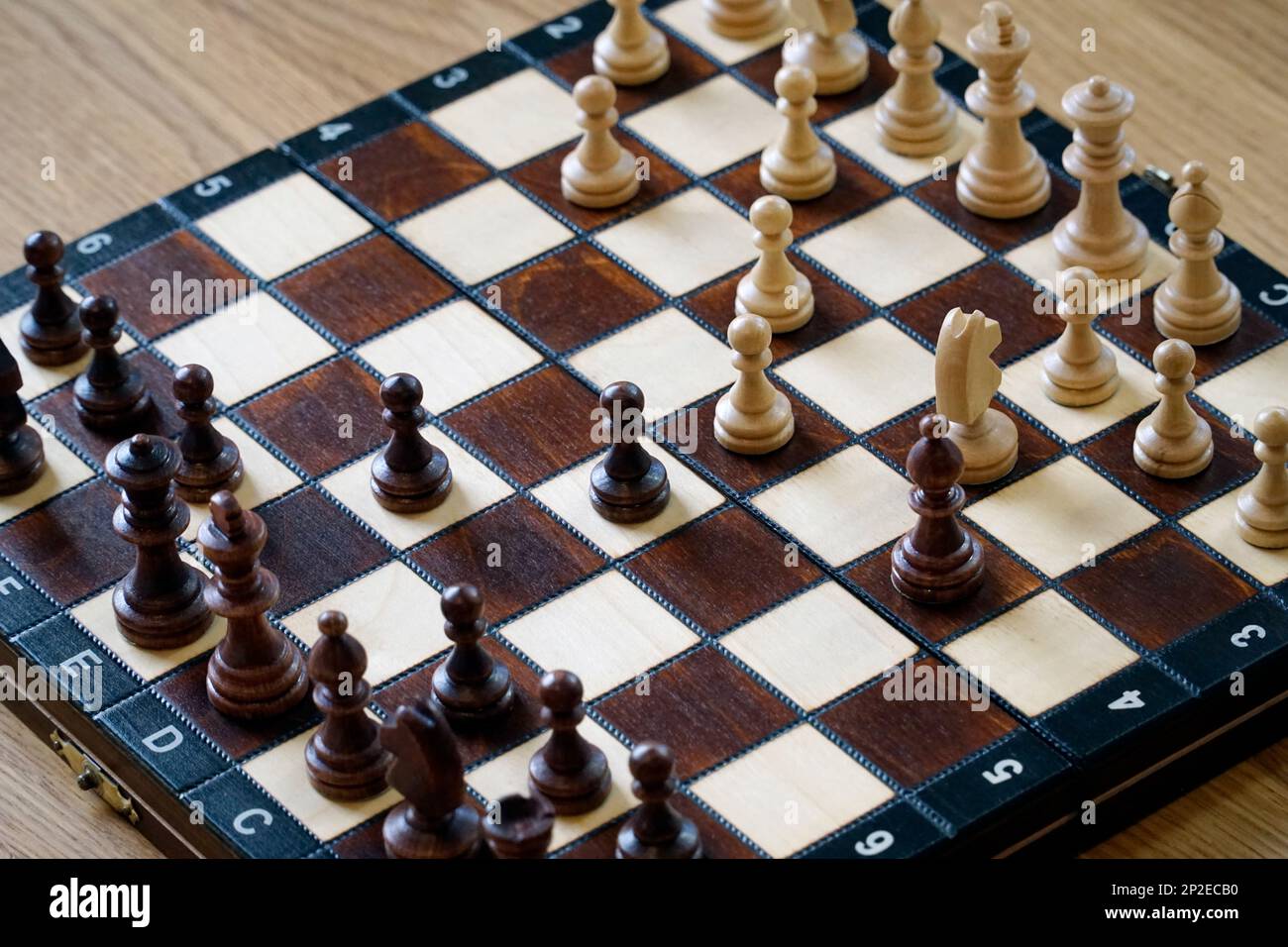 Black and white chess pieces on a board - top view Stock Photo