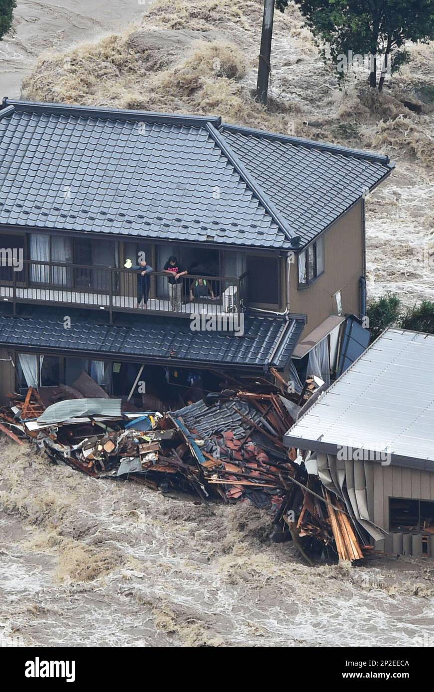 A photo shows residents asking for a help from a second floor of their ...