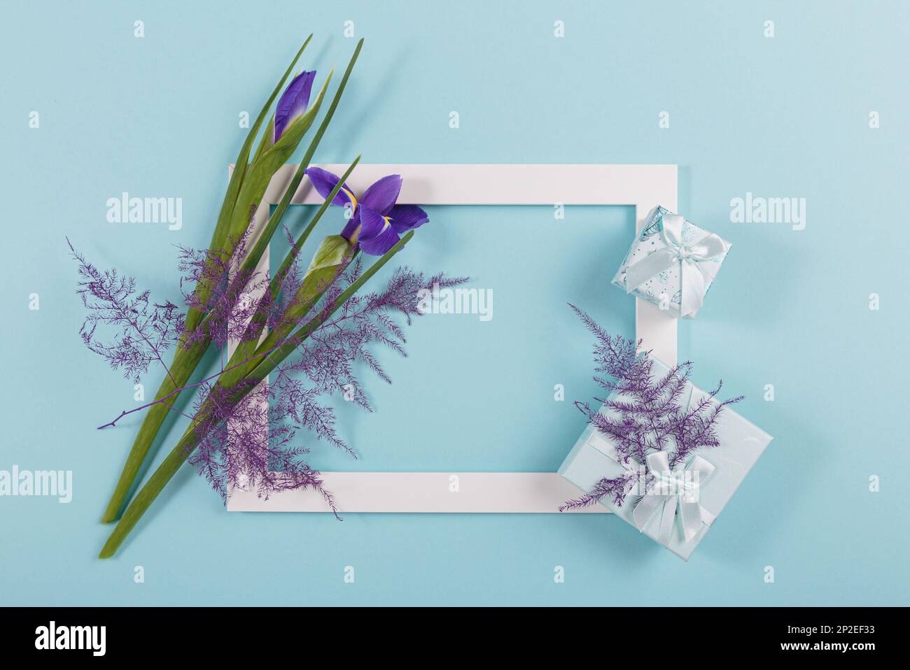 Blank greeting card mock up with irises flowers and gift boxes Stock