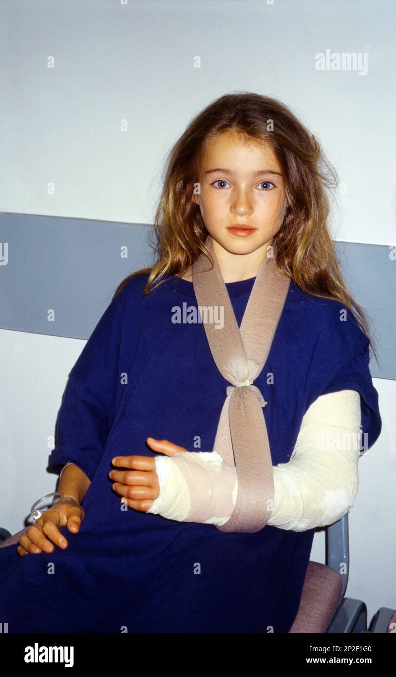 Girl With Arm In Plaster And Cannula with Intravenous Drip In Hand at Hospital England Stock Photo