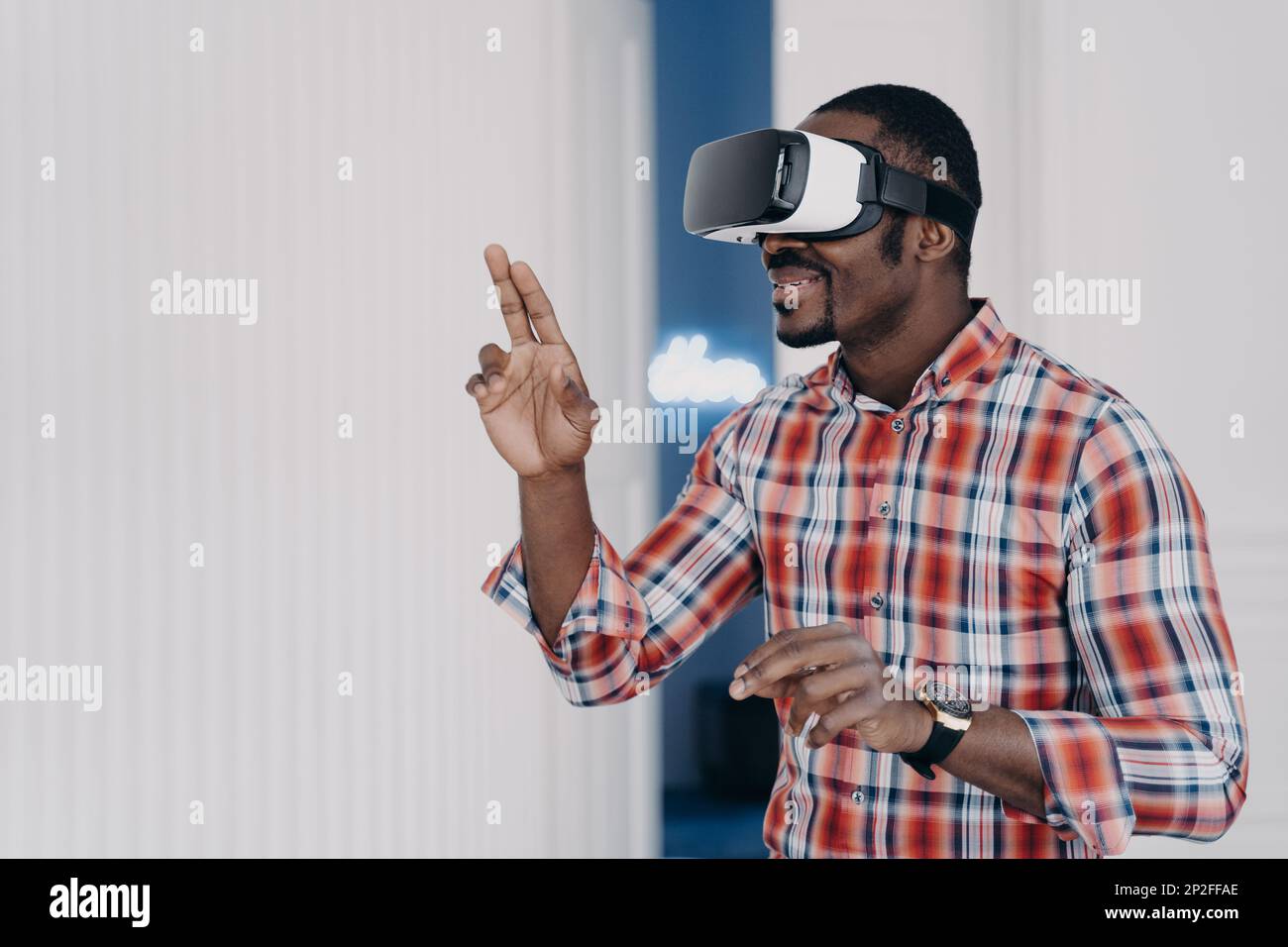 African american guy wearing virtual reality glasses, enjoying leisure free time in cyberspace. Modern black man playing video game simulation, testin Stock Photo