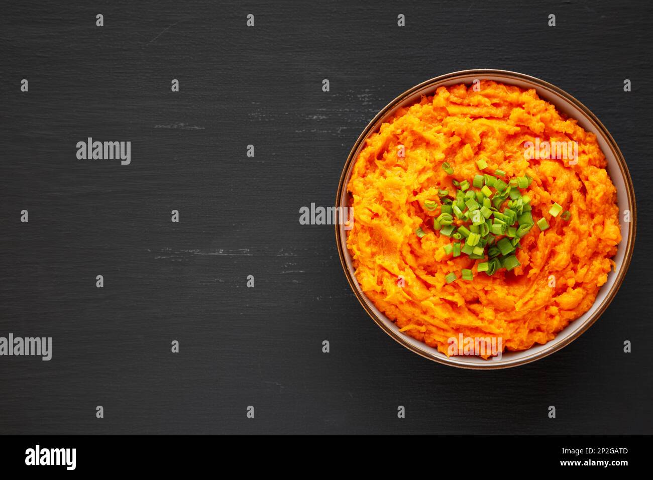 Homemade Creamy Mashed Sweet Potatoes with MIlk and Butter in a Bowl, top view. Space for text. Stock Photo