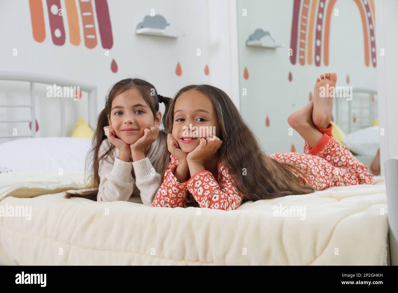 Cute girls in pajamas on bed at home Stock Photo - Alamy