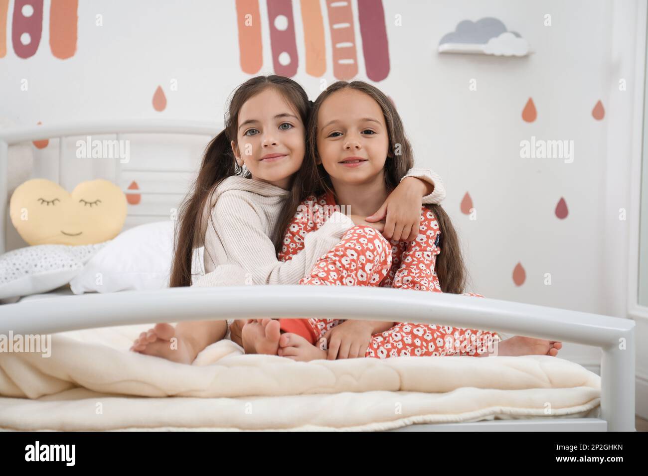 Cute girls in pajamas on bed at home Stock Photo - Alamy