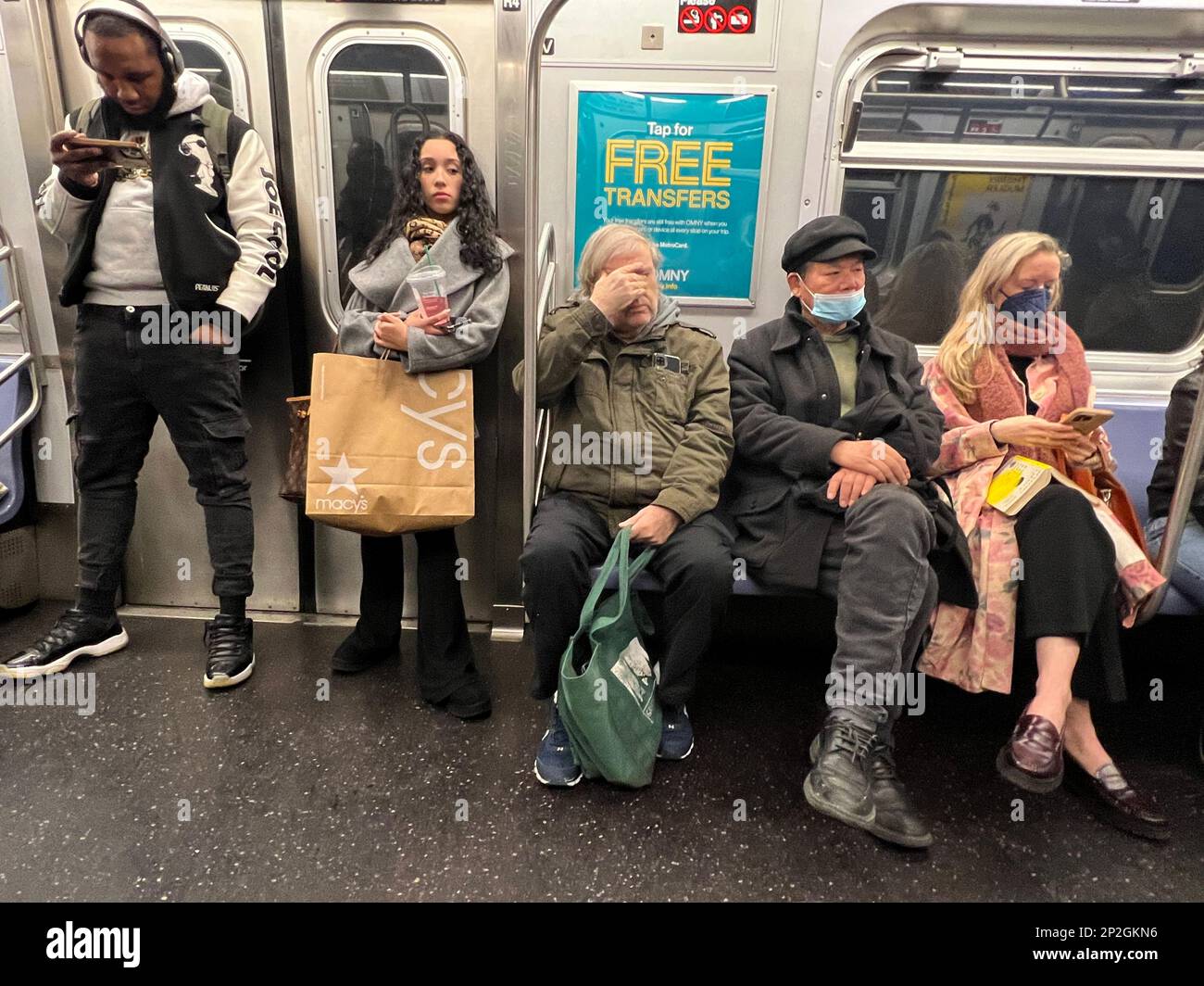 People riding a New York City subway train, some still wearing face masks in March 2023 Stock