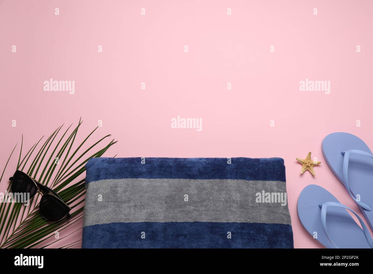 Beach towel, flip flops and sunglasses on pink background, flat lay ...