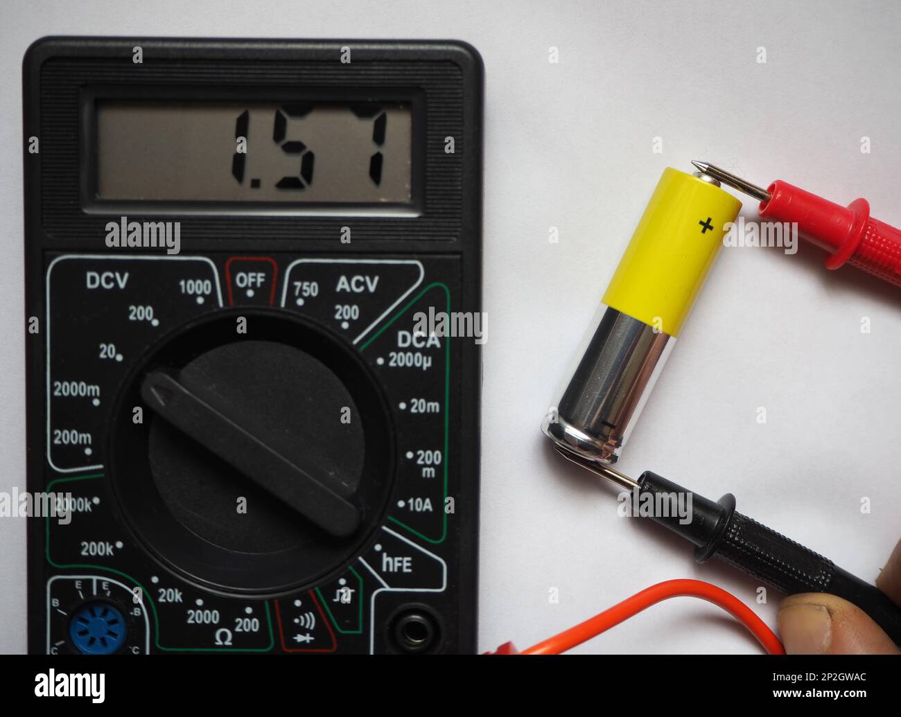 Voltage testing of AA type cell battery with a voltmeter. Stock Photo