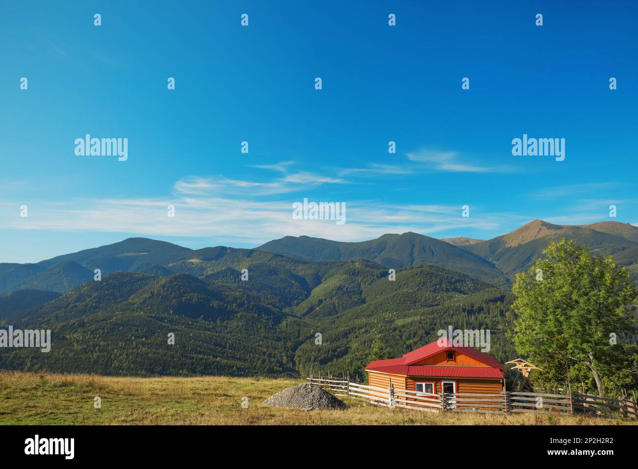 Picturesque view of sky with clouds over beautiful house in mountains ...