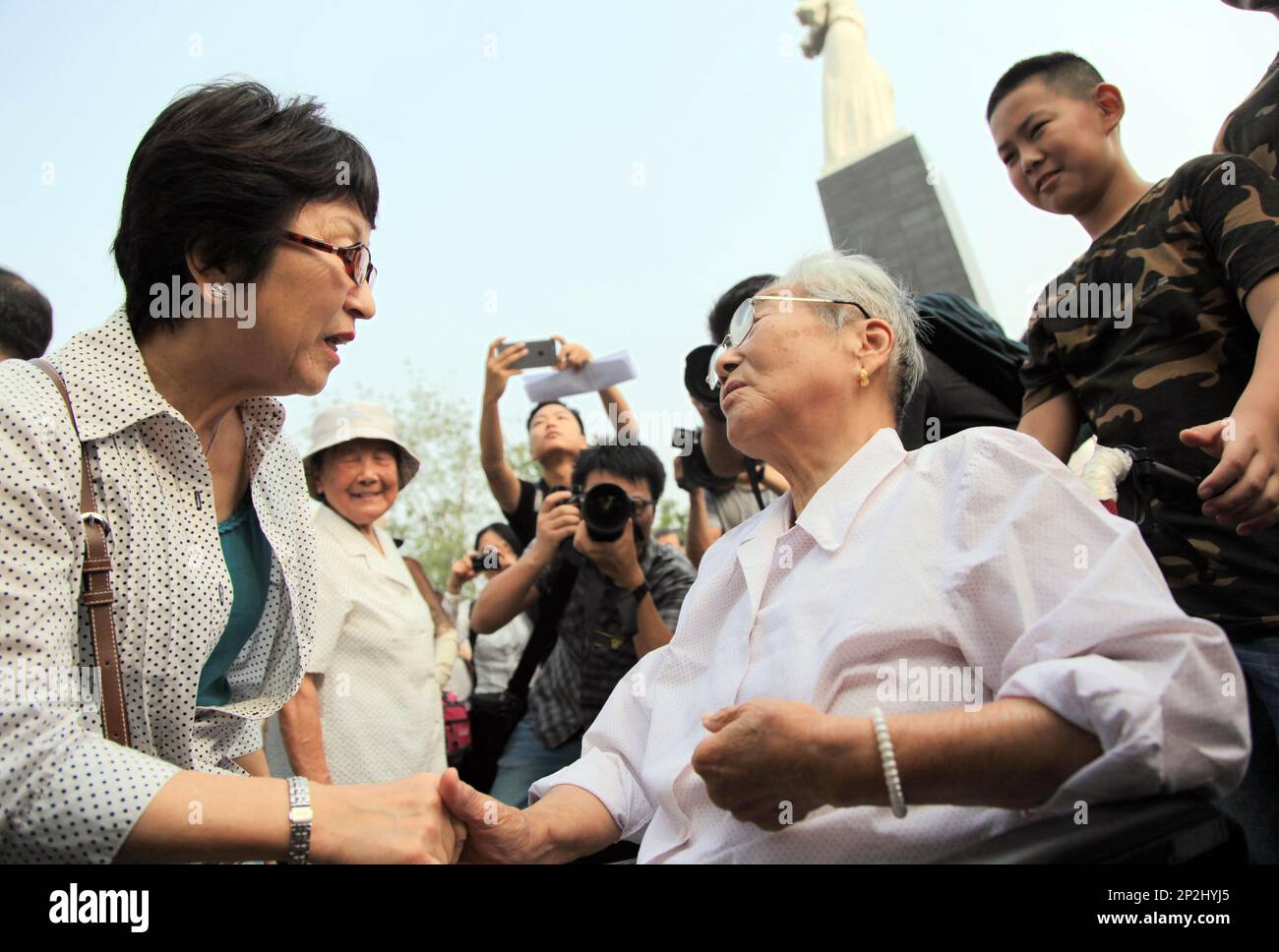 Japanese activist Tamaki Matsuoka, left, speaks with Chen Guixiang, a  Chinese survivor of the 1937 Nanjing Massacre, right, during a gathering at  Nanjing Massacre Memorial Hall in Nanjing in eastern China's Jiangsu
