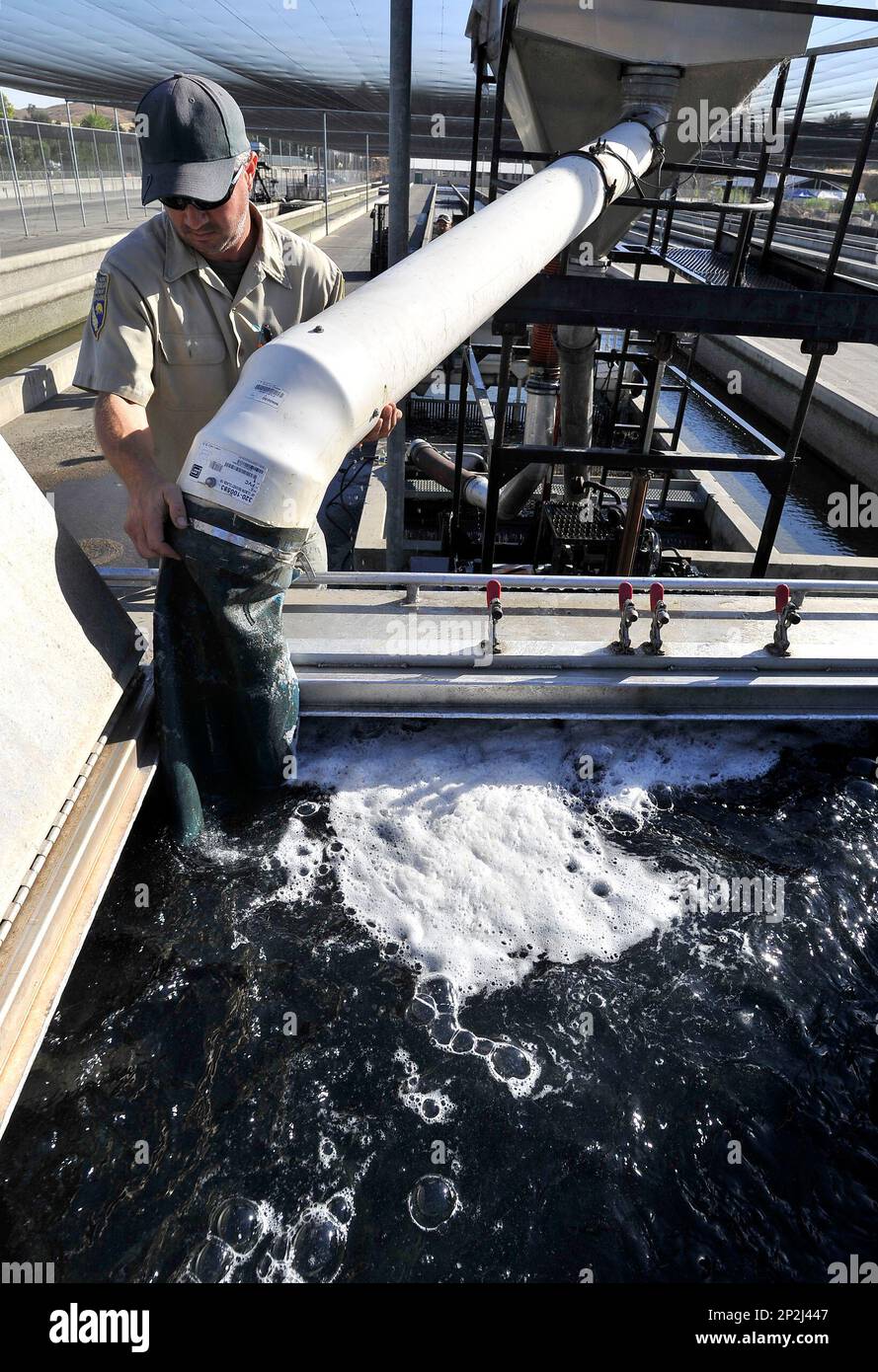 Mike Marty, of the California Fish and Wildlife Department, directs a pipe outflow taking
