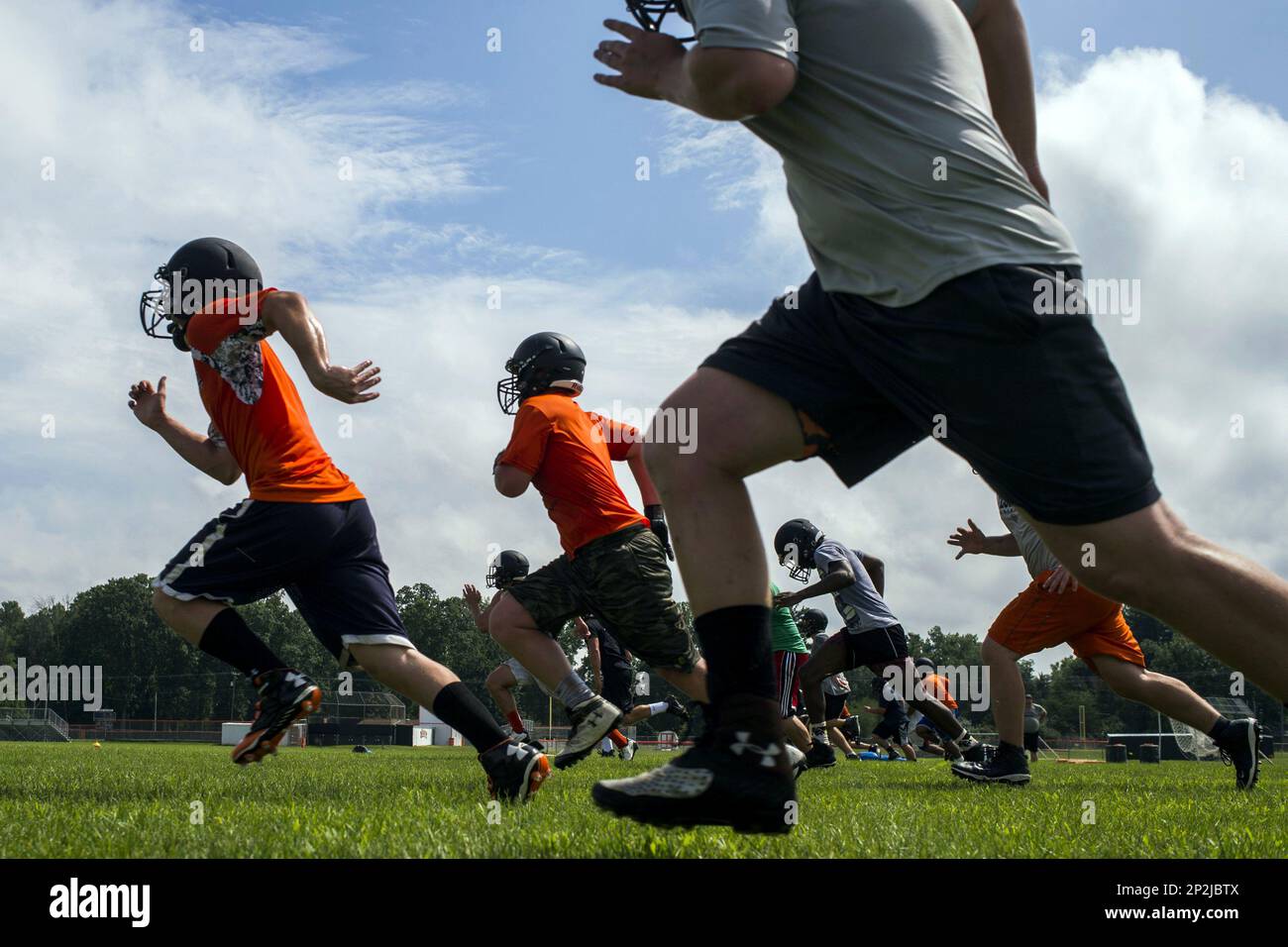 Flushing football players run sprints in waves on Monday, Aug. 10, 2015