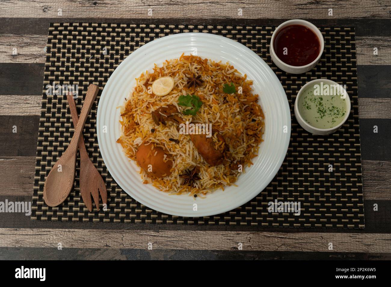 Chicken Biryani, popular Pakistani Indian food in a white plate on dark textured background. Stock Photo