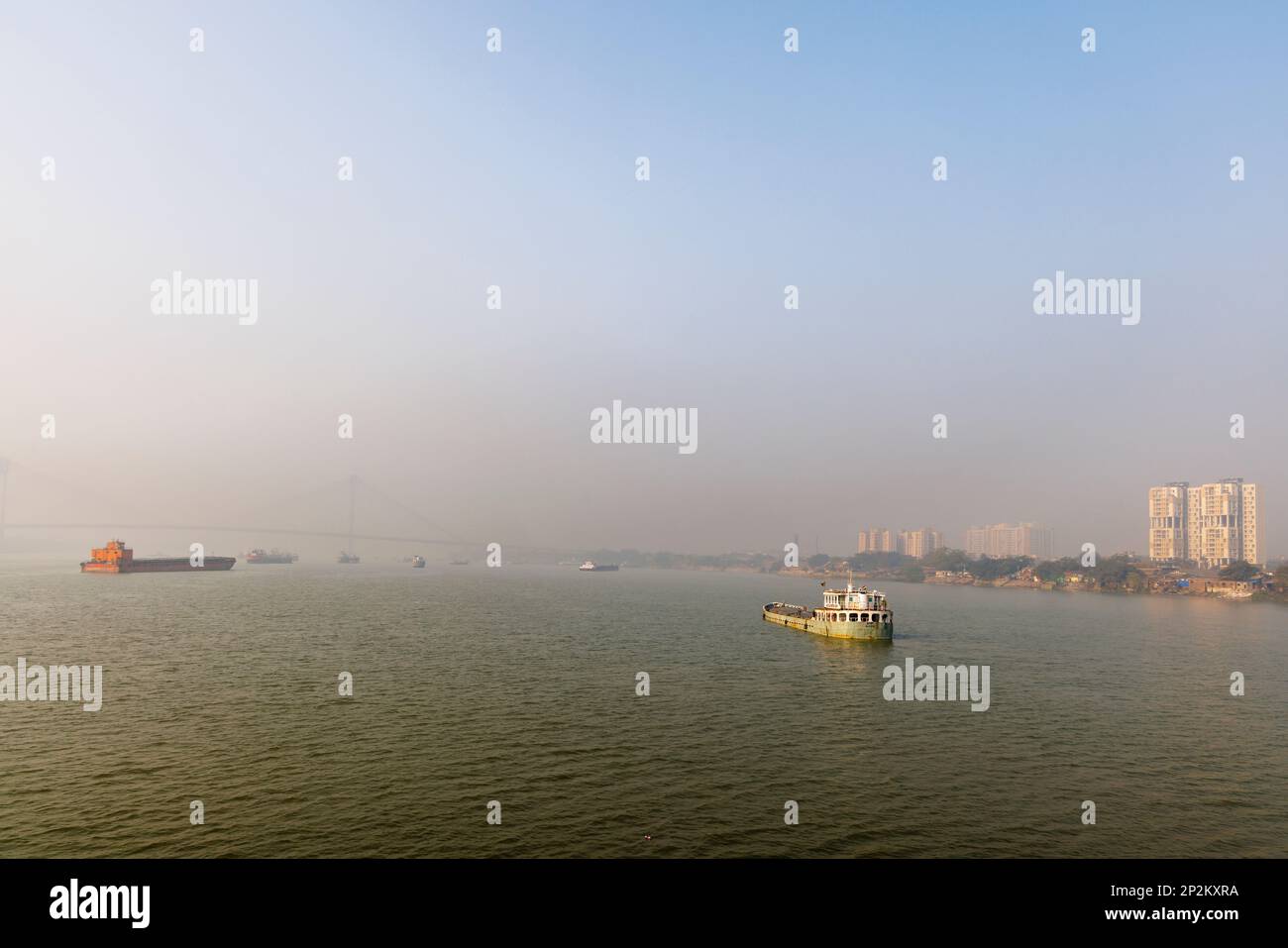 Boats moored and early morning smoggy atmosphere over the Hooghly River at Kolkata (Calcutta), capital city of West Bengal, India Stock Photo
