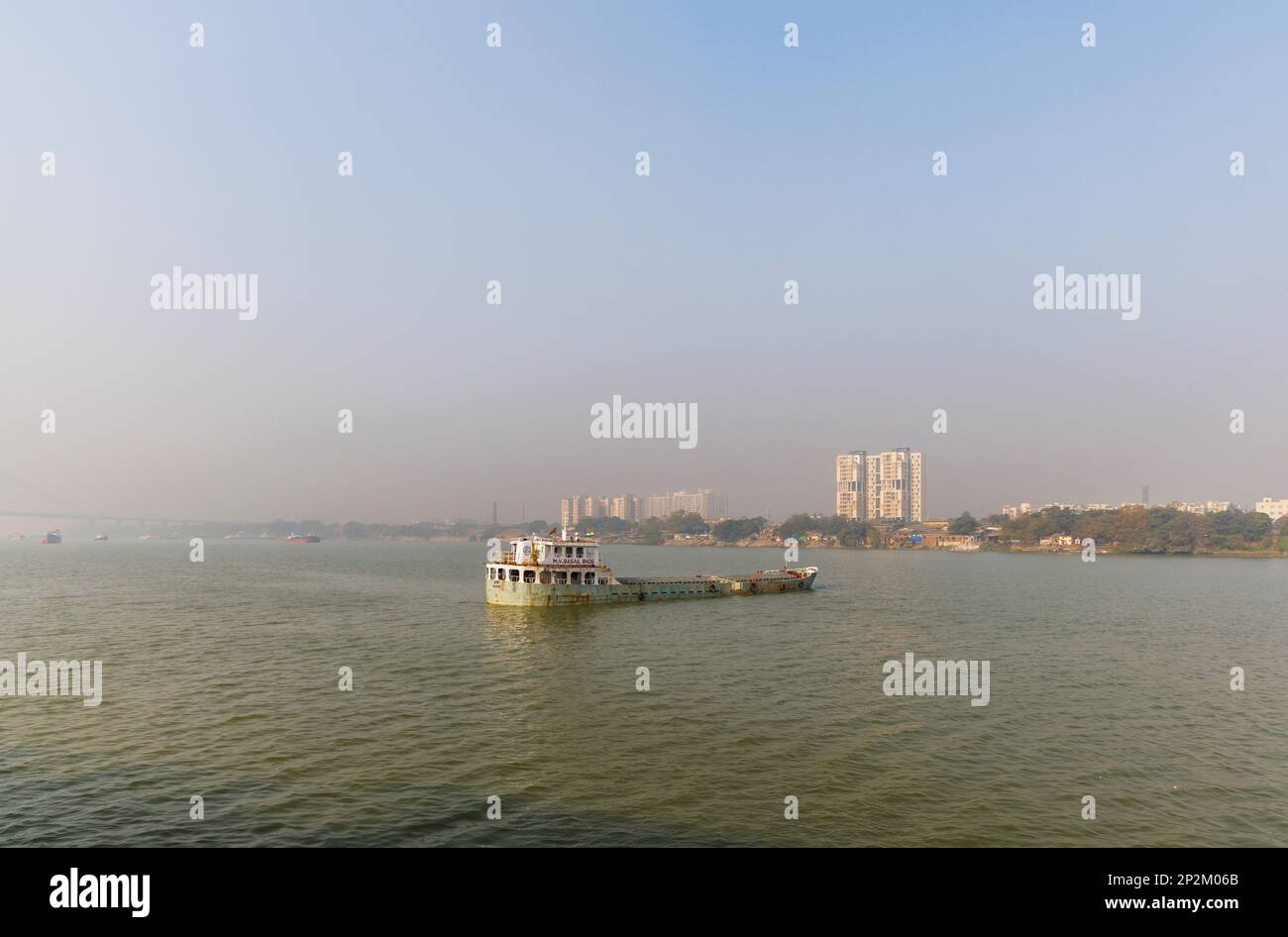 A boat moored and early morning smoggy atmosphere over the Hooghly River at Kolkata (Calcutta), capital city of West Bengal, India Stock Photo