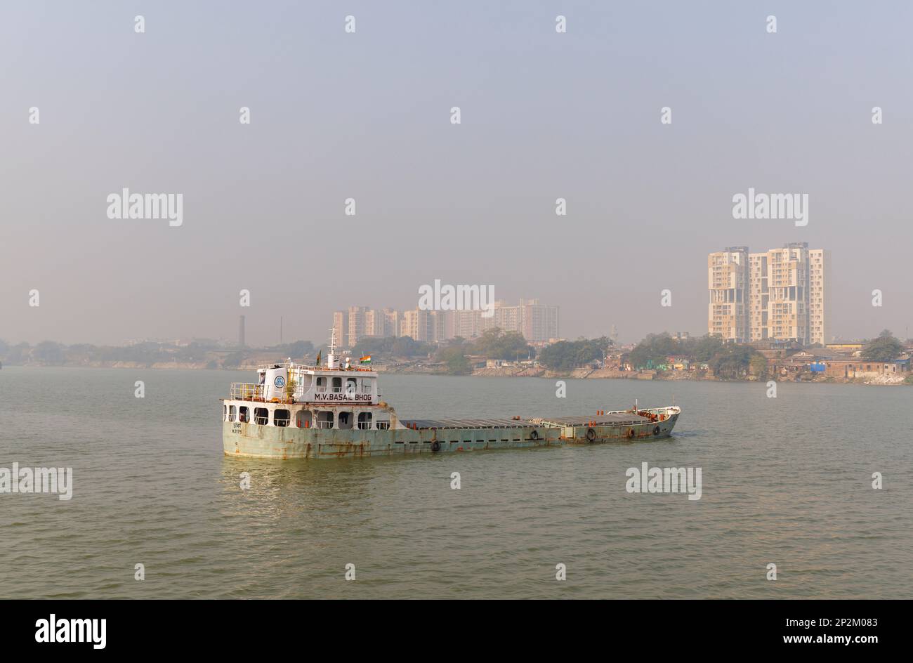 A boat moored and early morning smoggy atmosphere over the Hooghly River at Kolkata (Calcutta), capital city of West Bengal, India Stock Photo