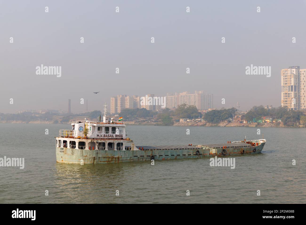 A boat moored and early morning smoggy atmosphere over the Hooghly River at Kolkata (Calcutta), capital city of West Bengal, India Stock Photo