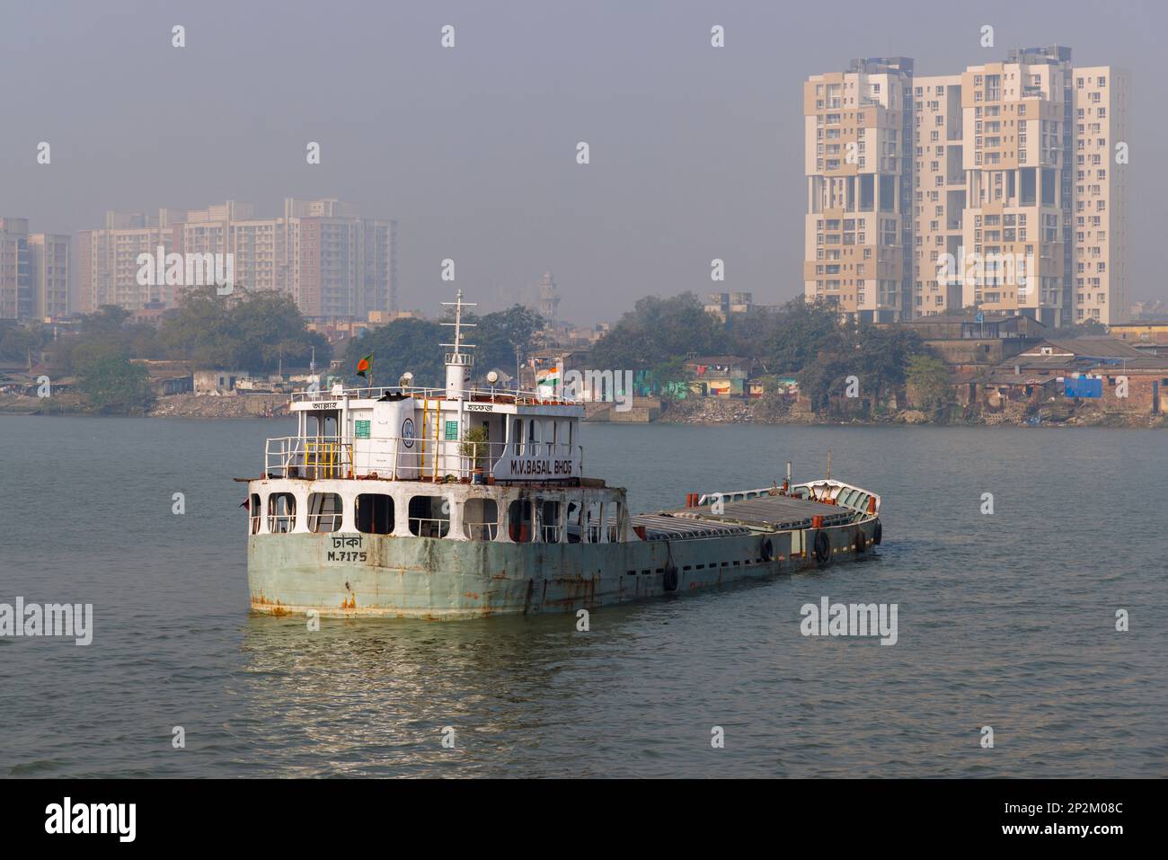 A boat moored and early morning smoggy atmosphere over the Hooghly River at Kolkata (Calcutta), capital city of West Bengal, India Stock Photo