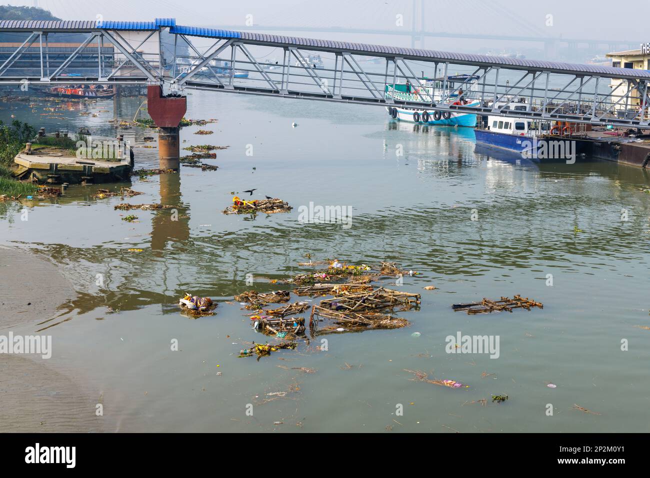 Rubbish and discarded effigies of the goddess Kali on the riverbank, River Police Jetty on the Hooghly River at Kolkata (Calcutta), West Bengal, India Stock Photo