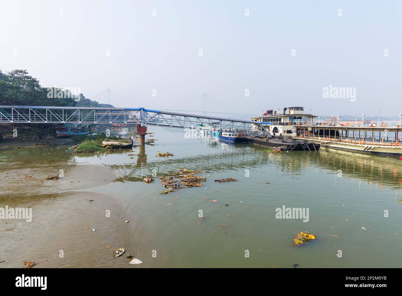 Rubbish and discarded effigies of the goddess Kali on the riverbank, River Police Jetty on the Hooghly River at Kolkata (Calcutta), West Bengal, India Stock Photo