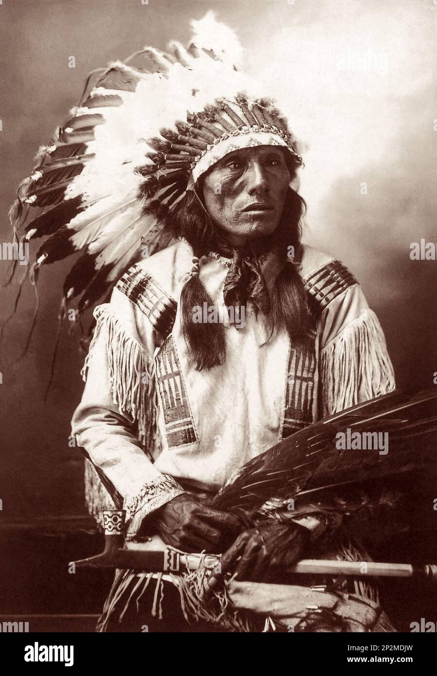 Studio portrait of Sioux Chief High Horse (1852-1931) in 1900 with a golden eagle wing tip fan and a black stone lead inlaid pipe. (Photo by John A. Anderson) Stock Photo